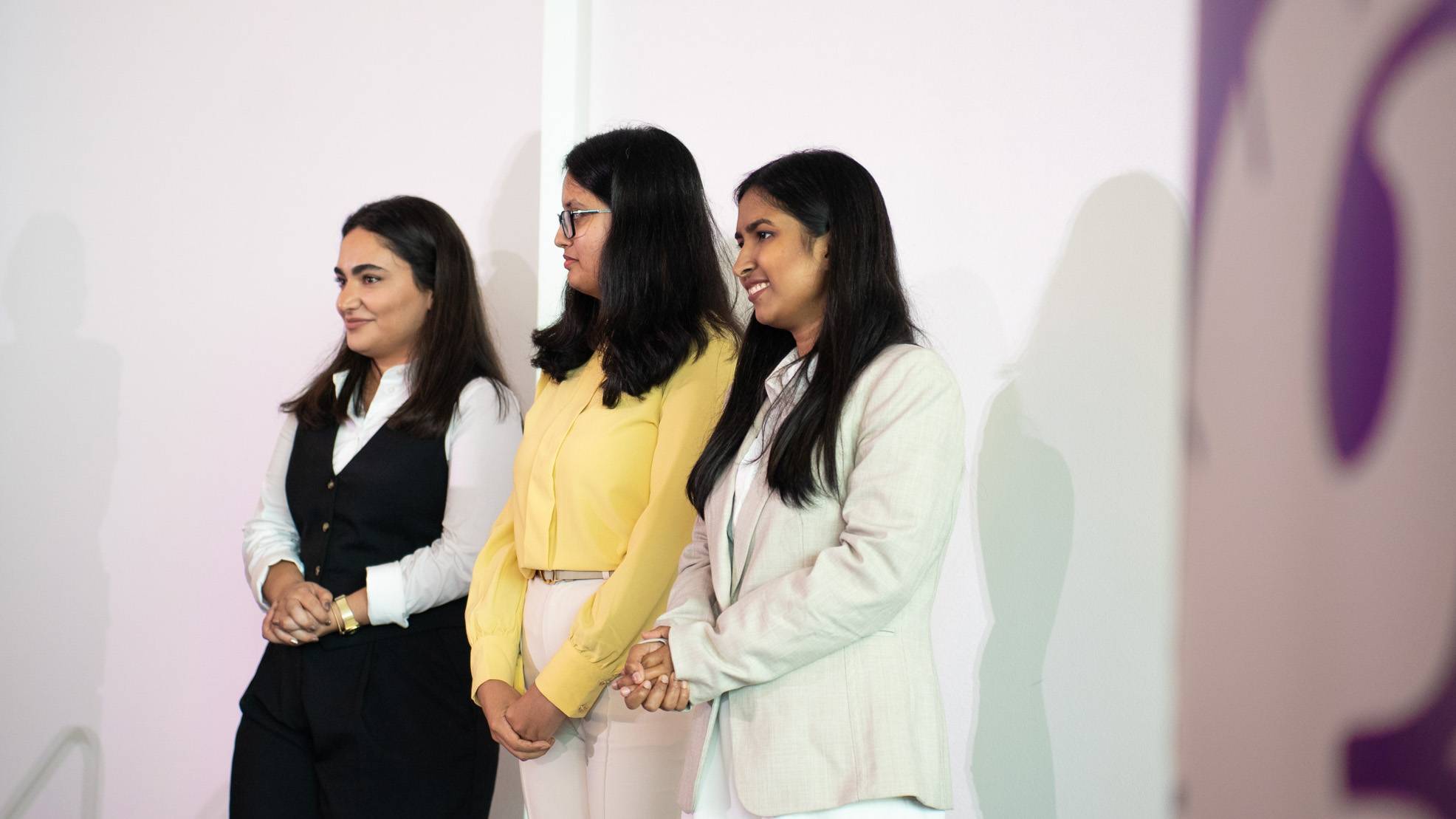 Kimia Feiz (left), Maria Sultana, and Anjumand Ashraf pose for a photo at the 3MT competition.