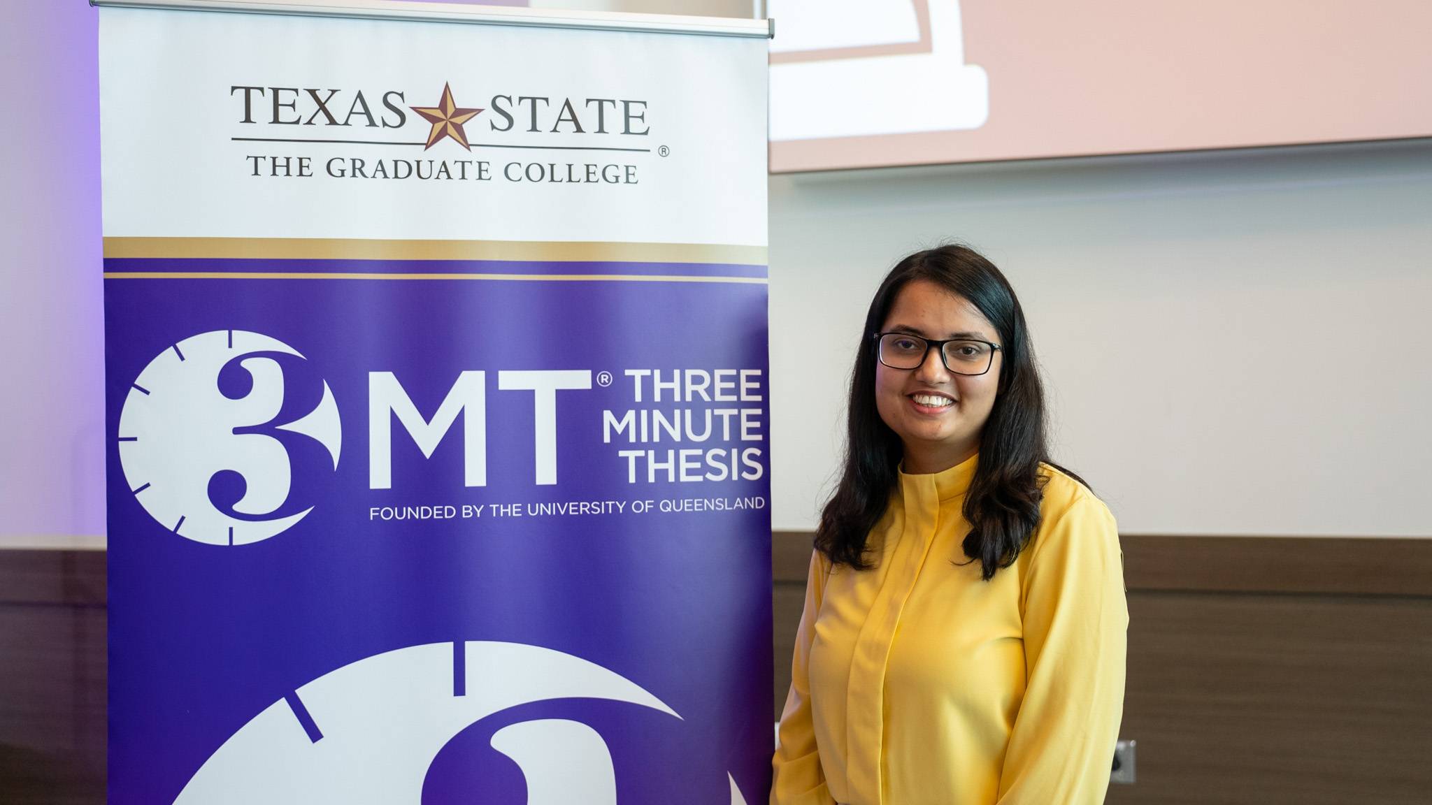 Maria Sultana poses for a photo next to the 3MT sign.