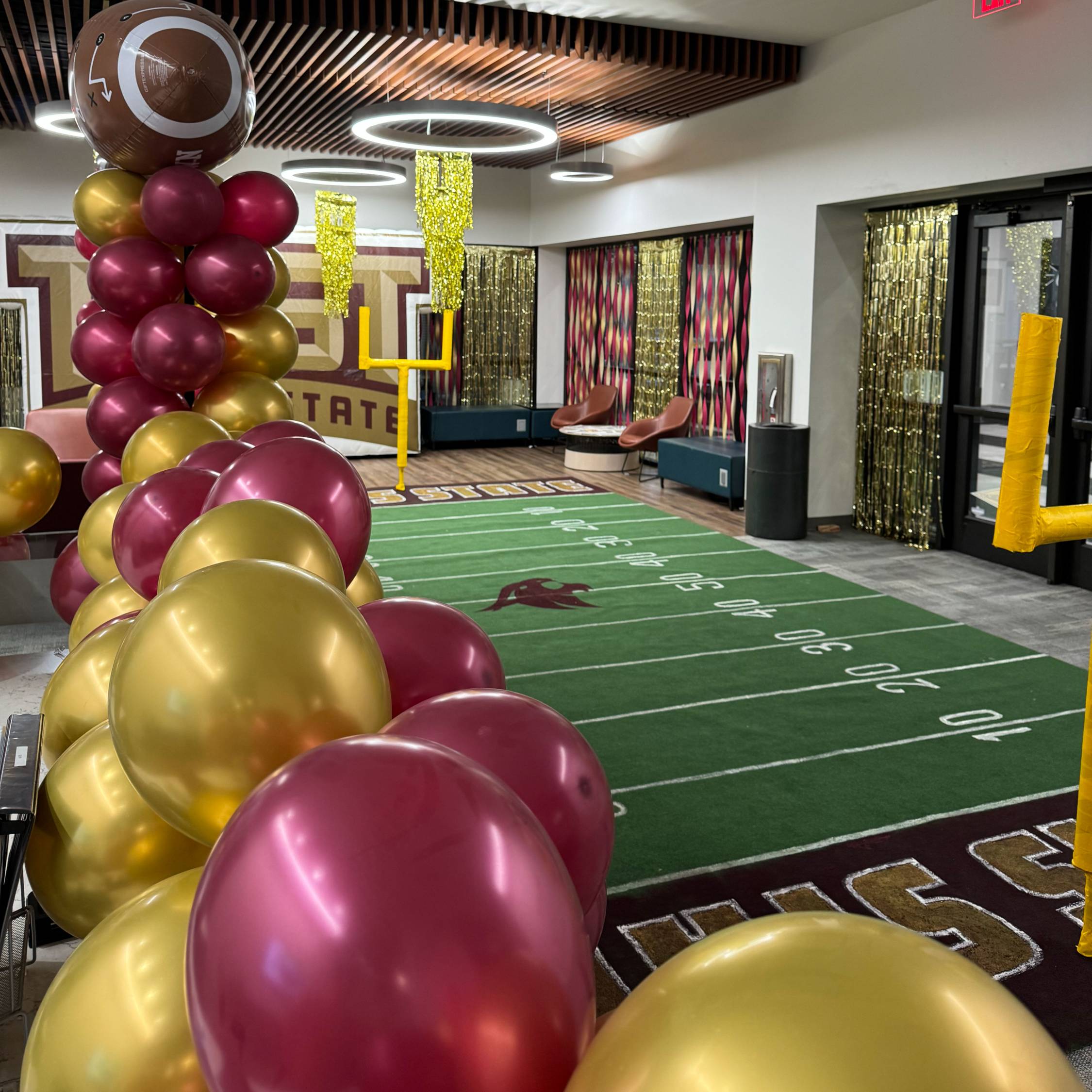 UFCU football field spread throughout the floor of the front office. Decorated with balloons along the edges.