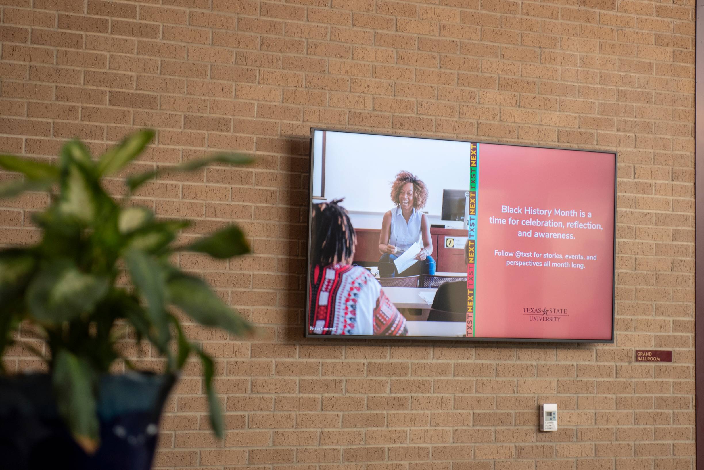 digital screen showing a promotion on a brick wall