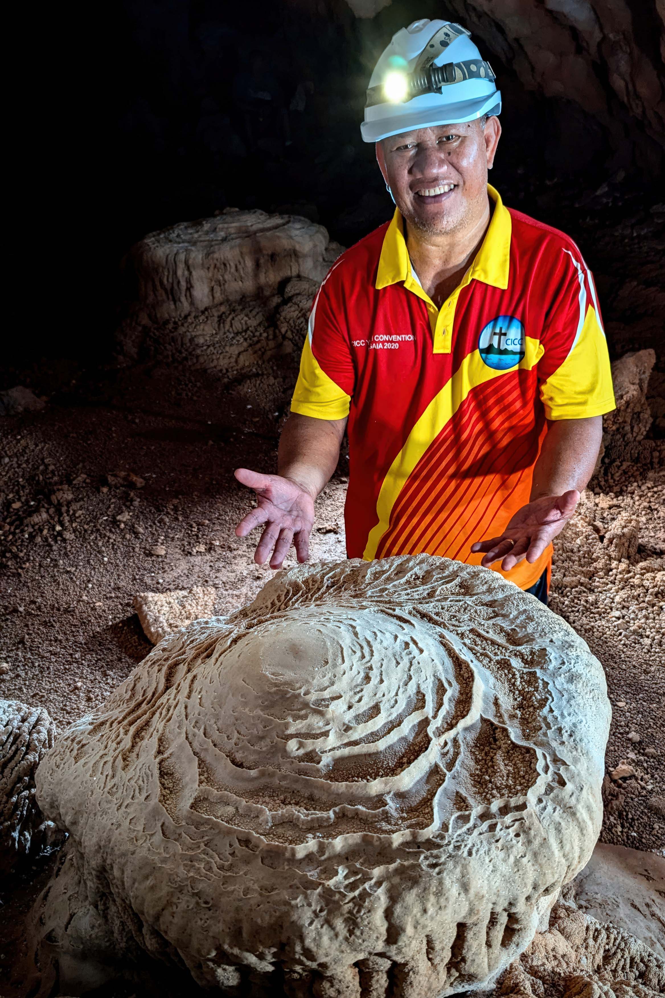 A member of Hutchins' team poses for a photo in front of a fossil.