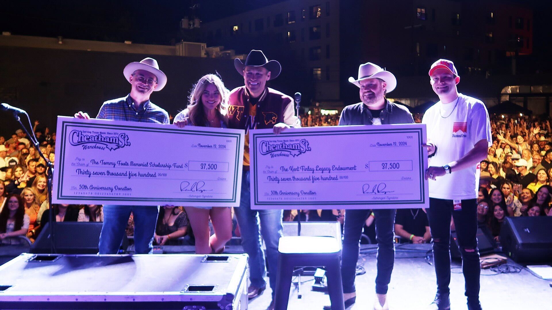 people on stage holding a check