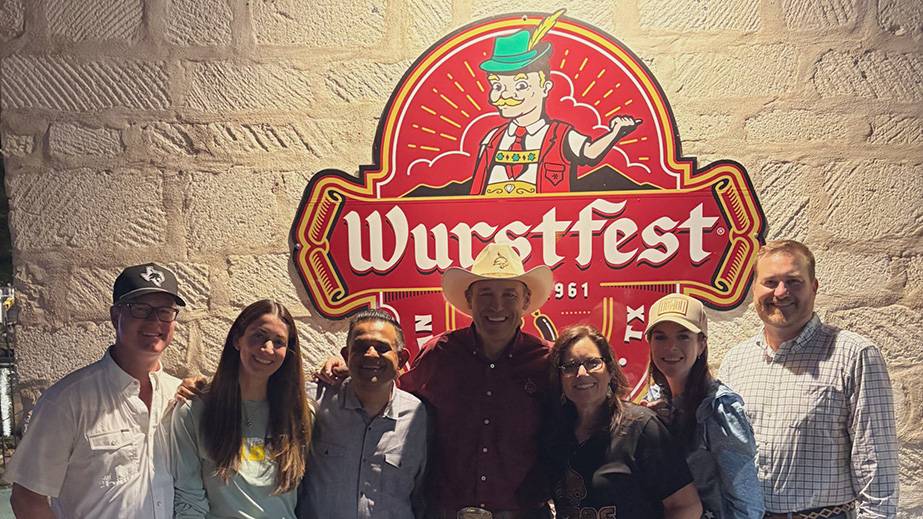 President Kelly Damphousse and First Lady Damphousse (middle) pose for a photo with friends at Wurstfest.