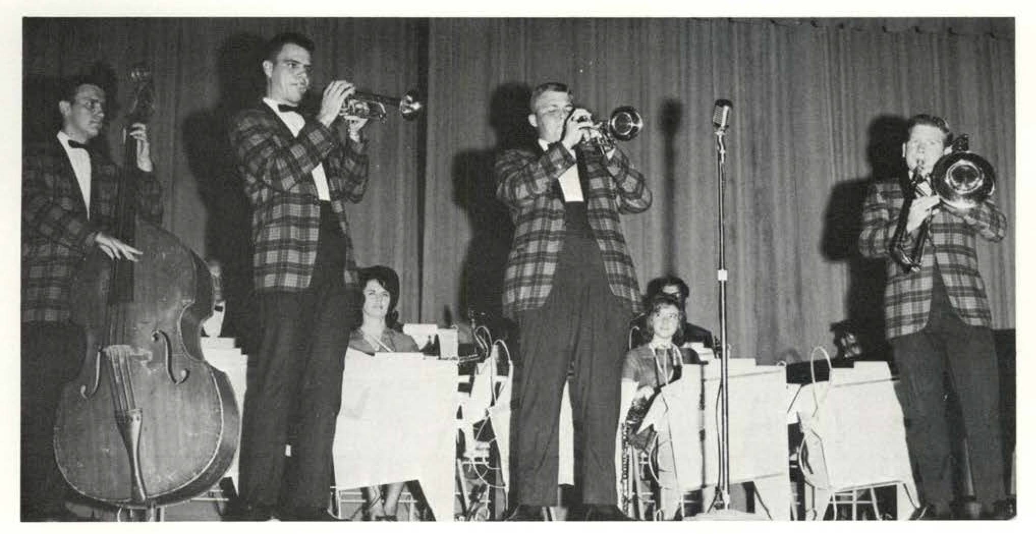 Members of The Stage Band perform at a school concert in 1966. Shown are the double bass player, two trumpet players, and a trombone player.