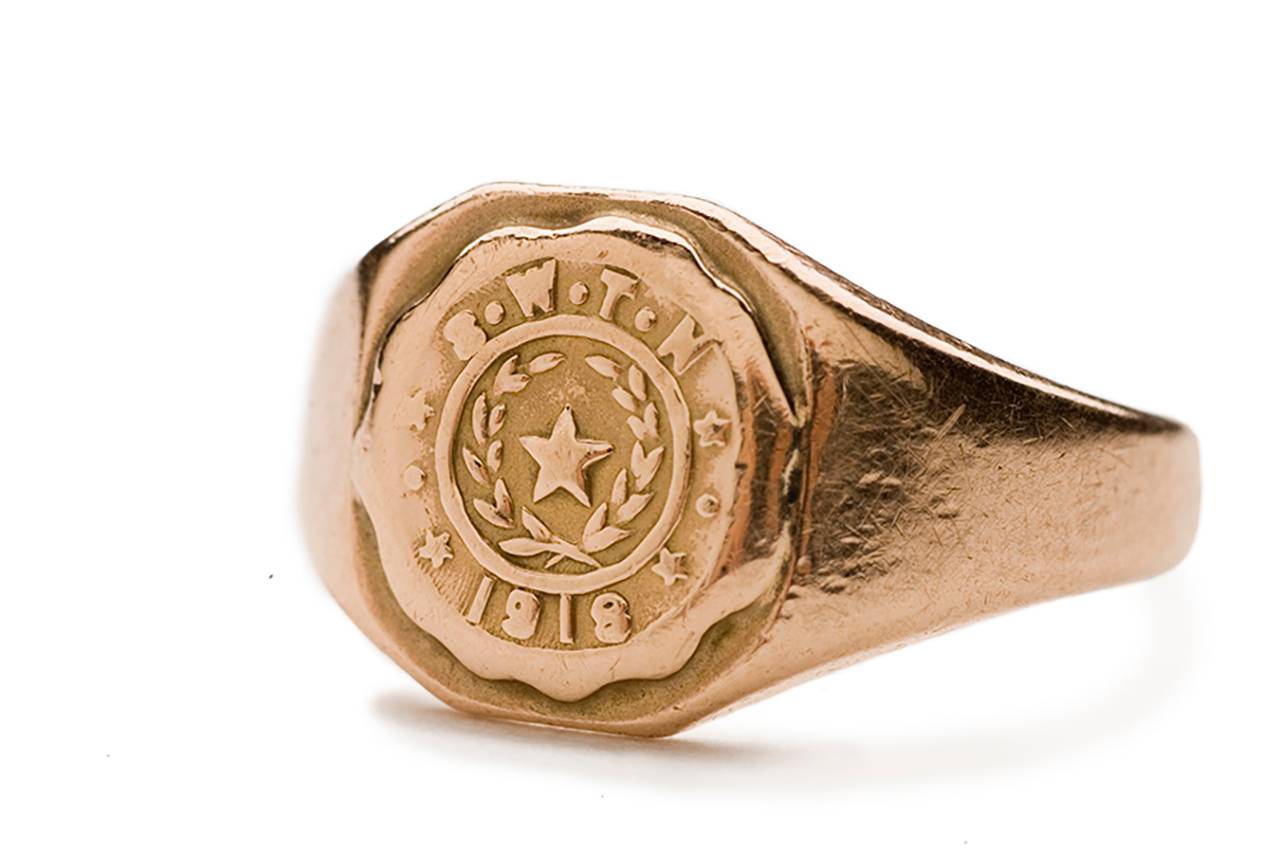 Aged golden class ring from 1918. Reads SWTN with a star in the middle.