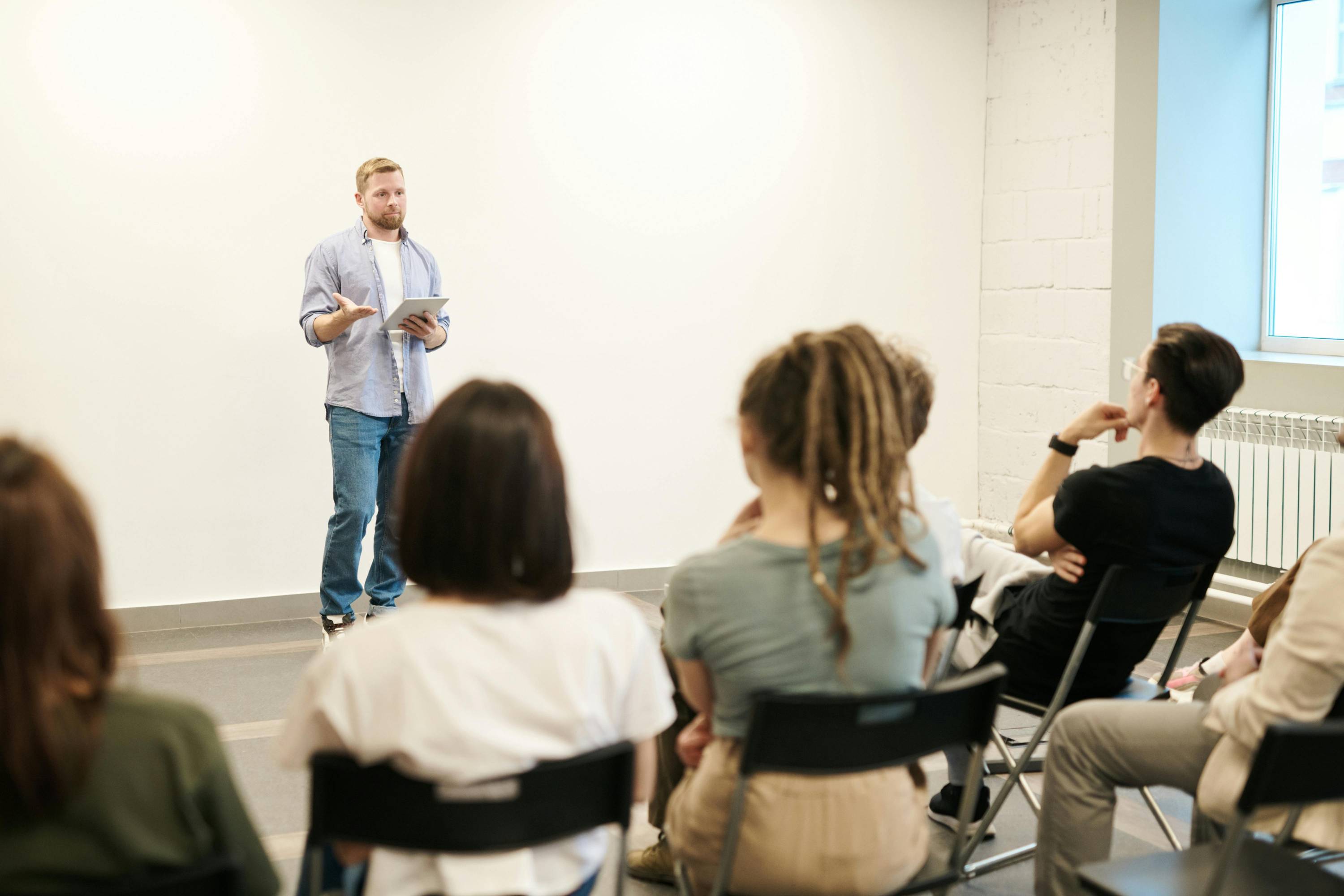 A man speaking at the front of the classroom 