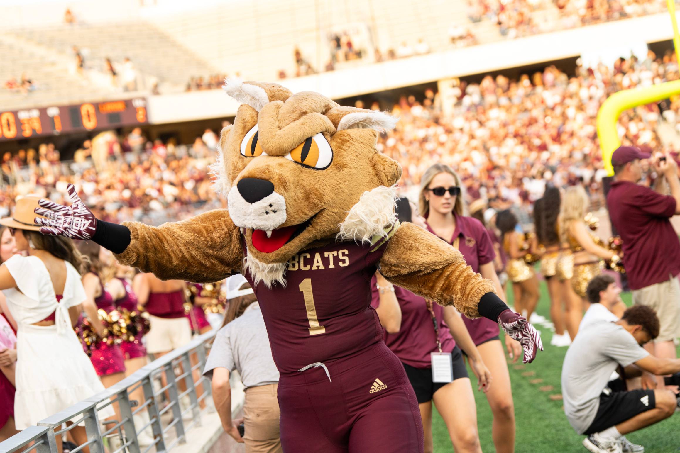 bobcat mascot posing for photo on basketball court