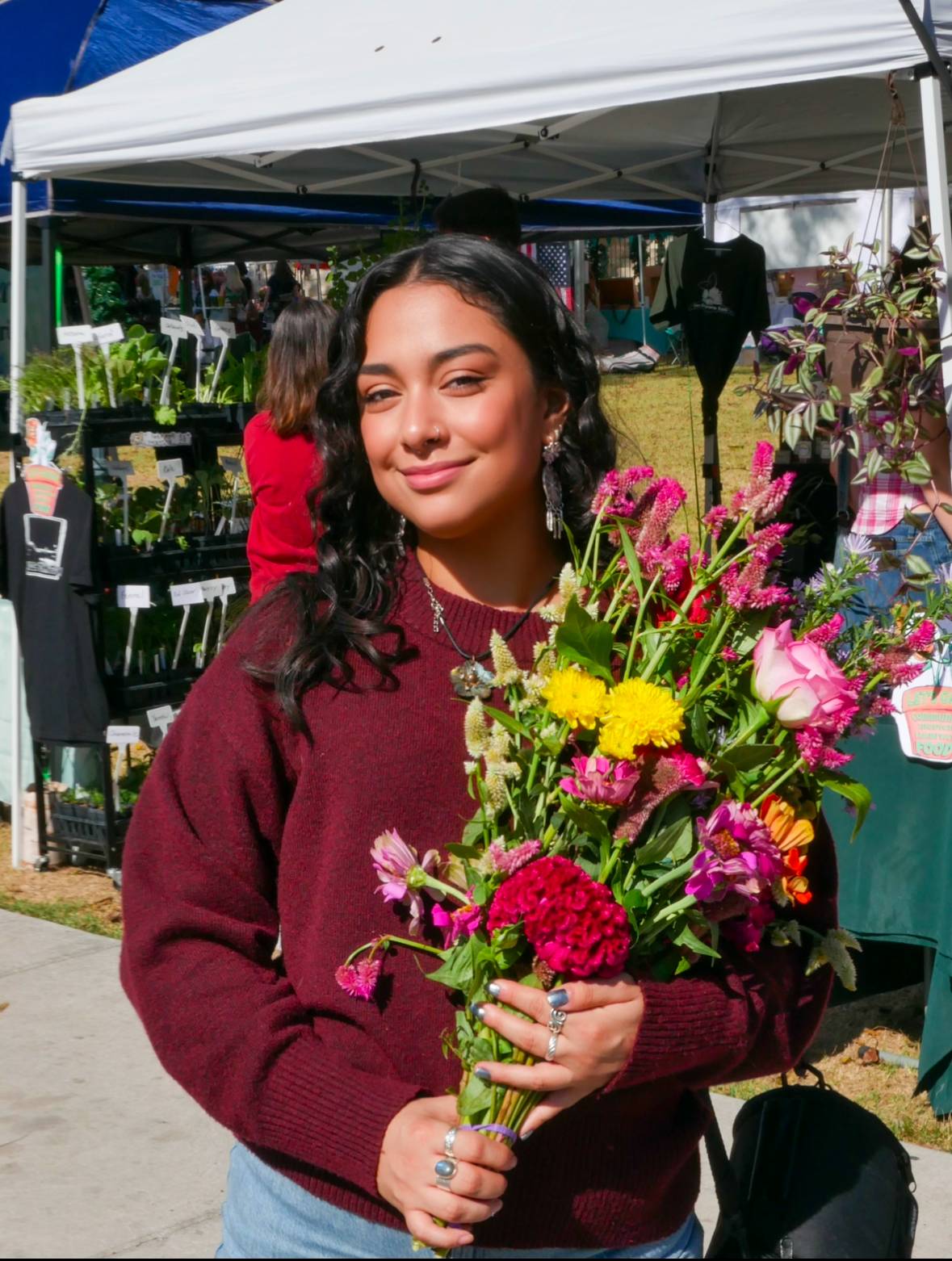 woman wearing red sweater and holding flowers