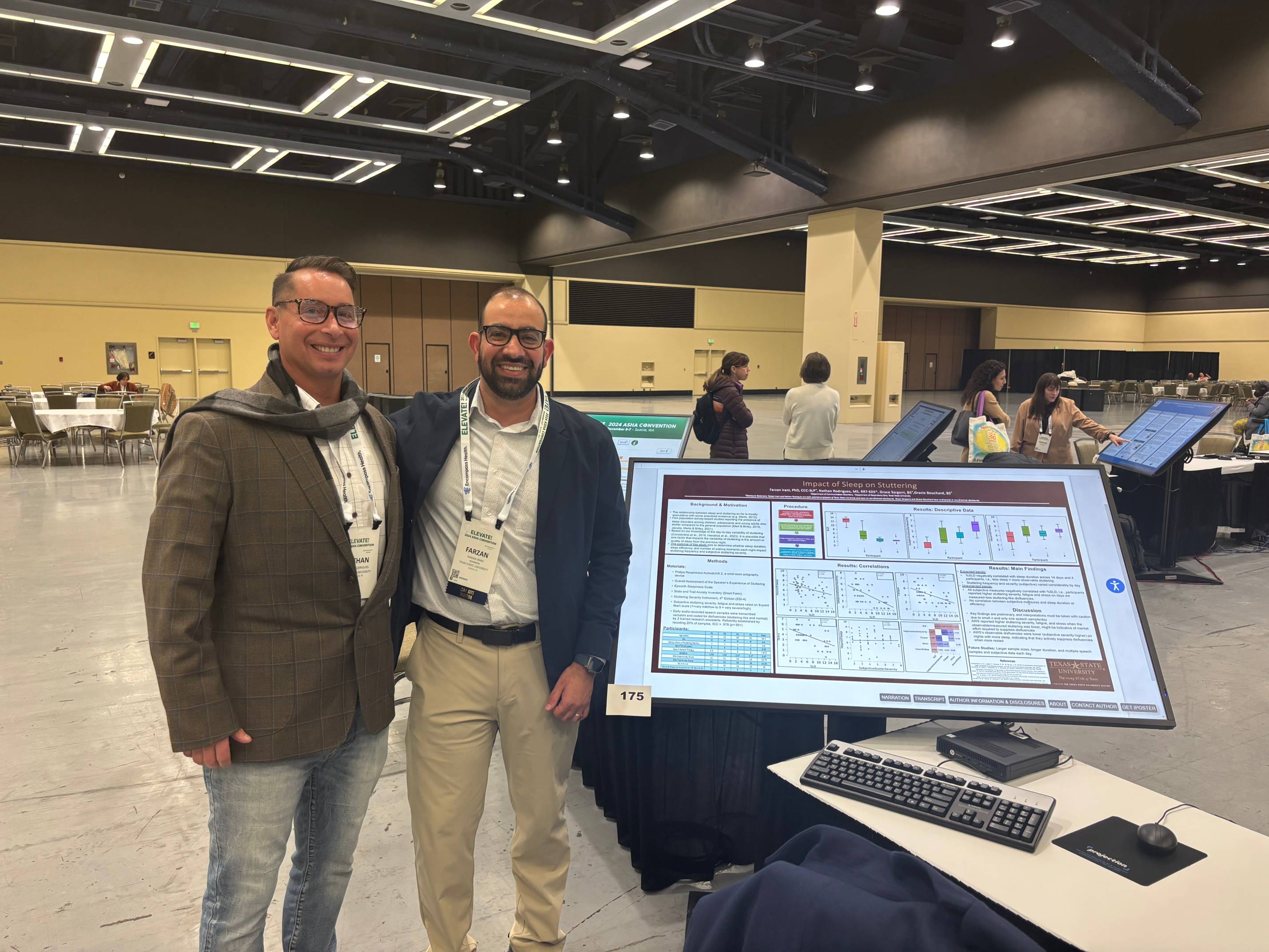 Dr. Irani and Mr. Rodrigues standing next to the poster.