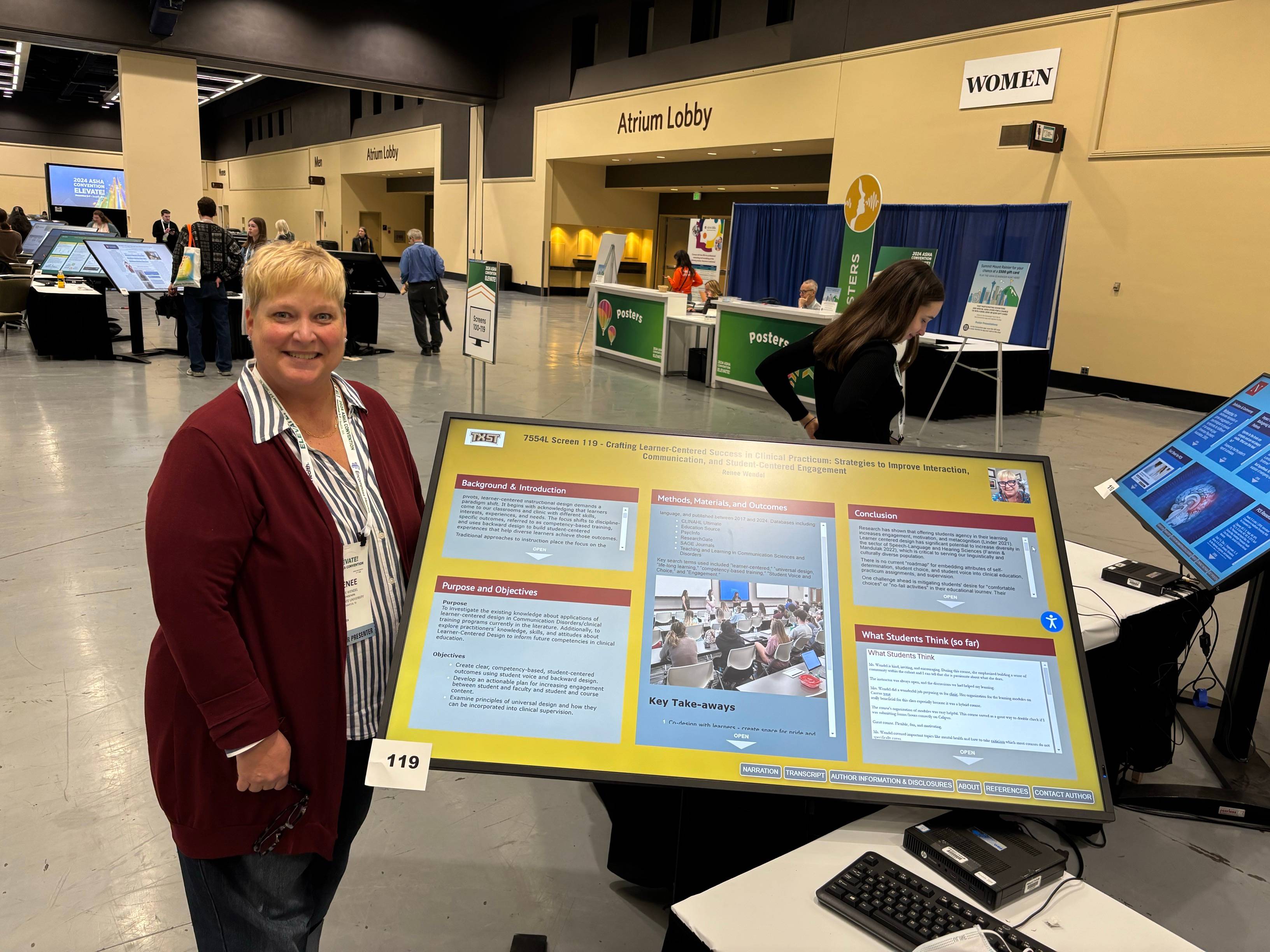 Ms. Wendel standing next to her poster in the ASHA Convention