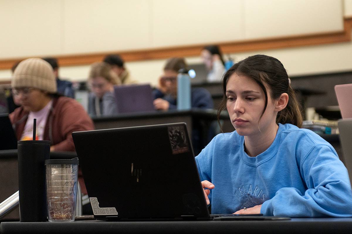 female student using a laptop in a classroom setting