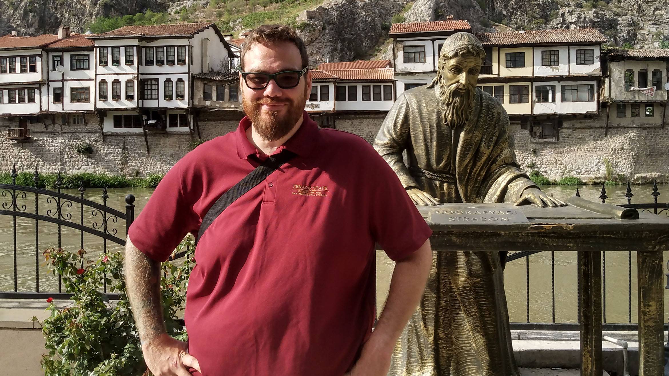 Dustin Sanchez poses for a photo in Amaysa next to a statue.