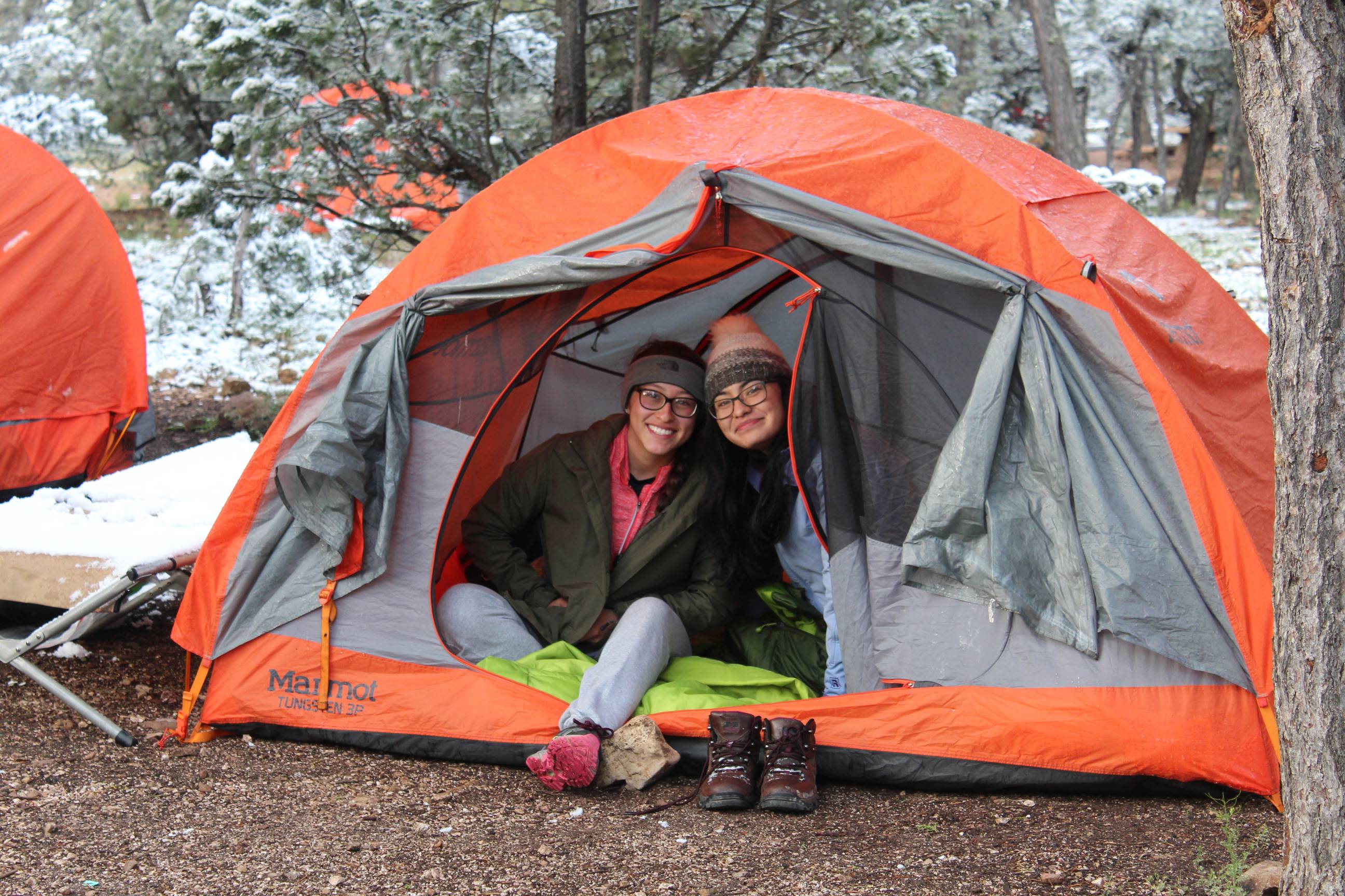 two students posing for a photo with a tent