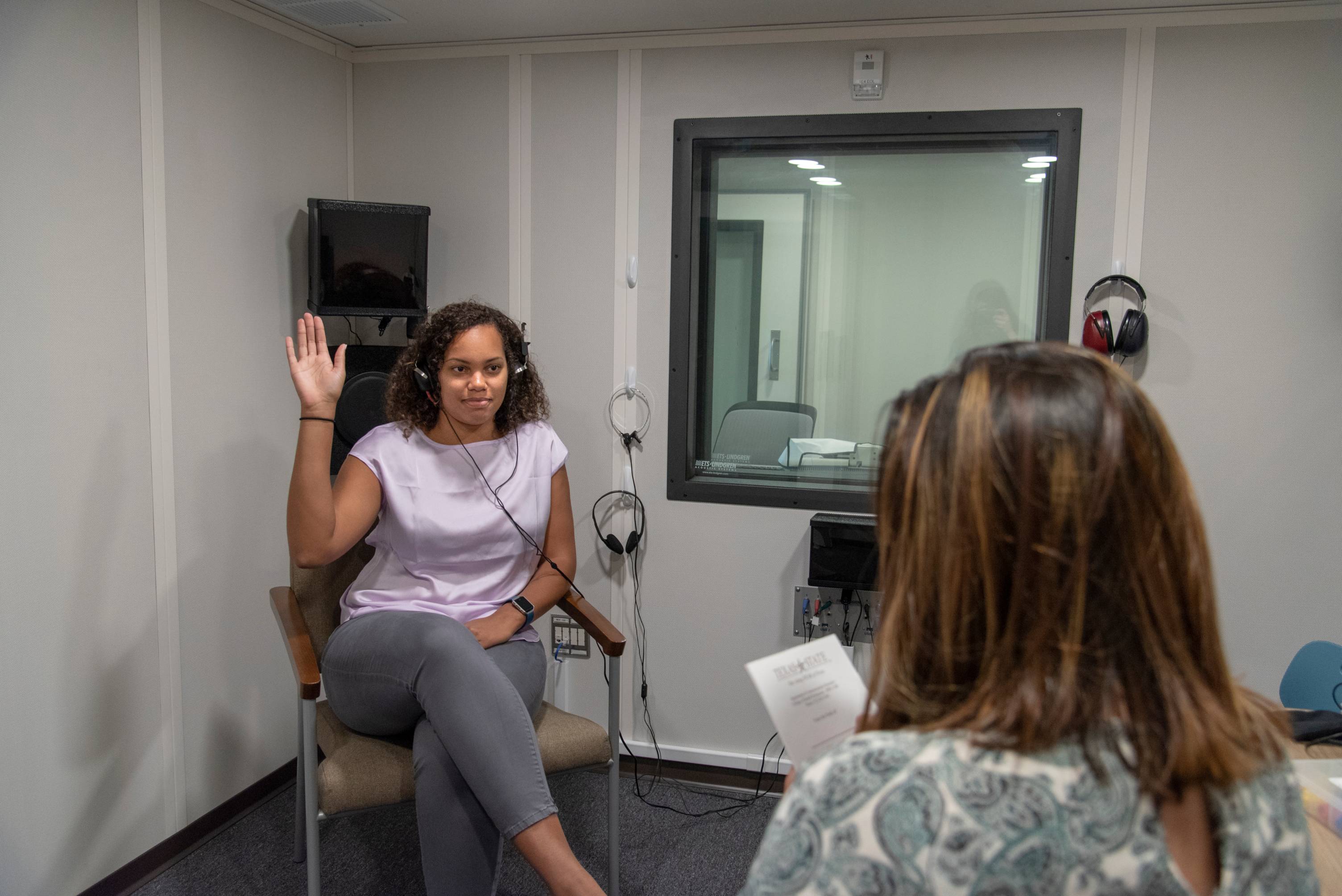 A student gives a hearing test to a colleague in the Hearing Lab at Willow Hall.