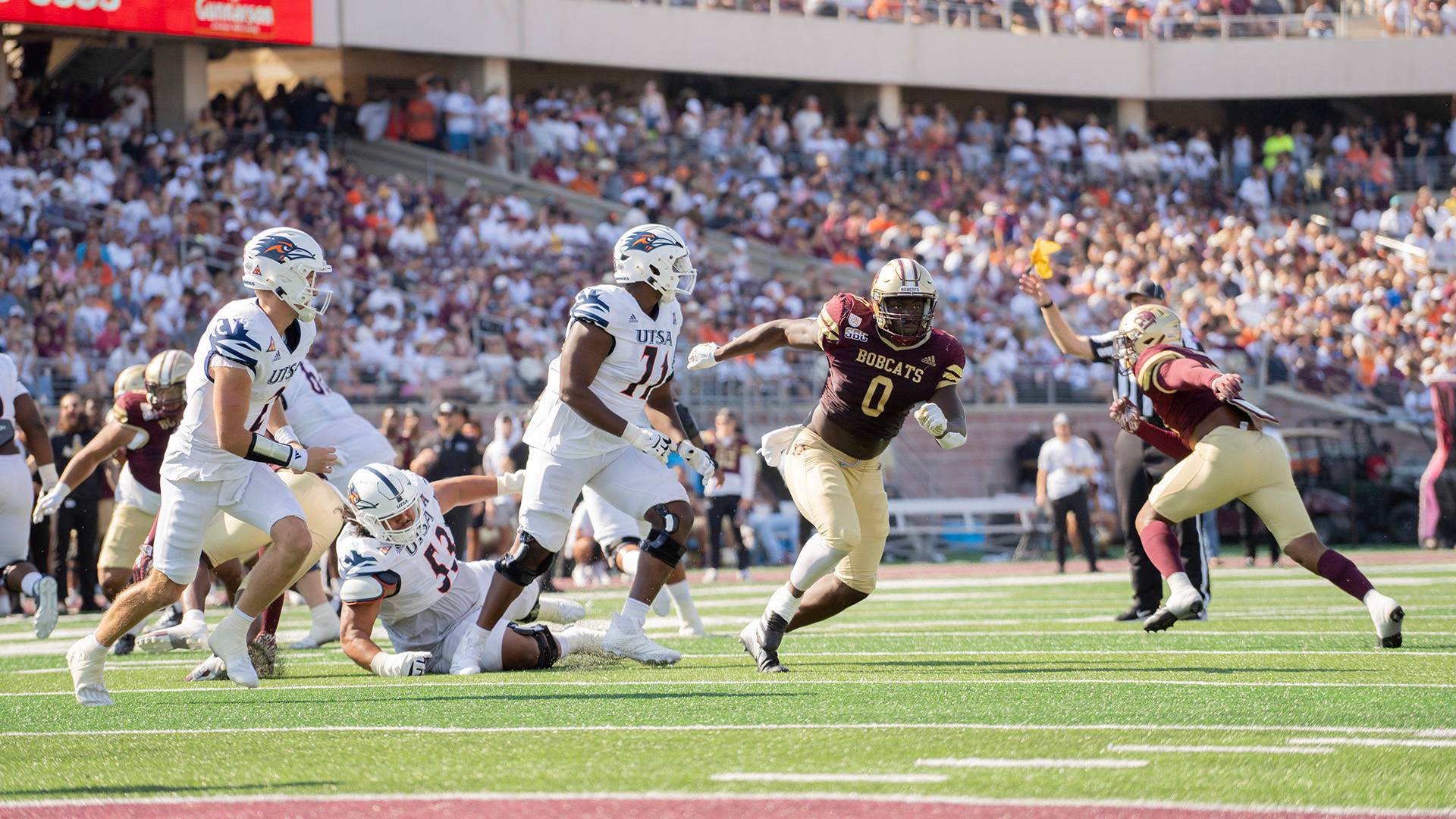 Bobcats football players running a play against rival team UTSA during a sold-out game.