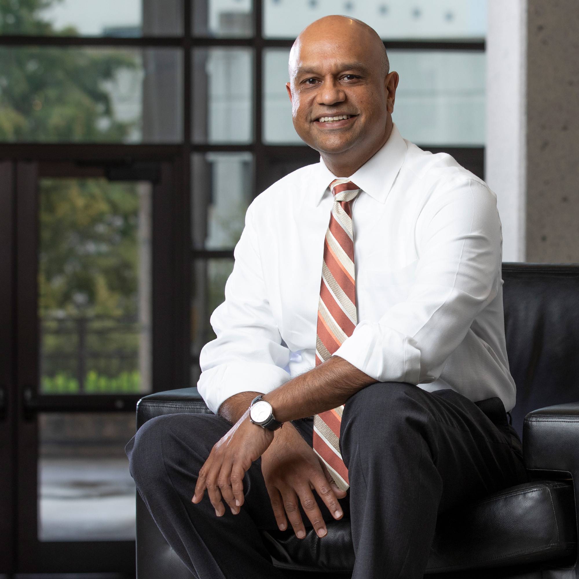 Sanjay Ramchander sitting in dress shirt and tie