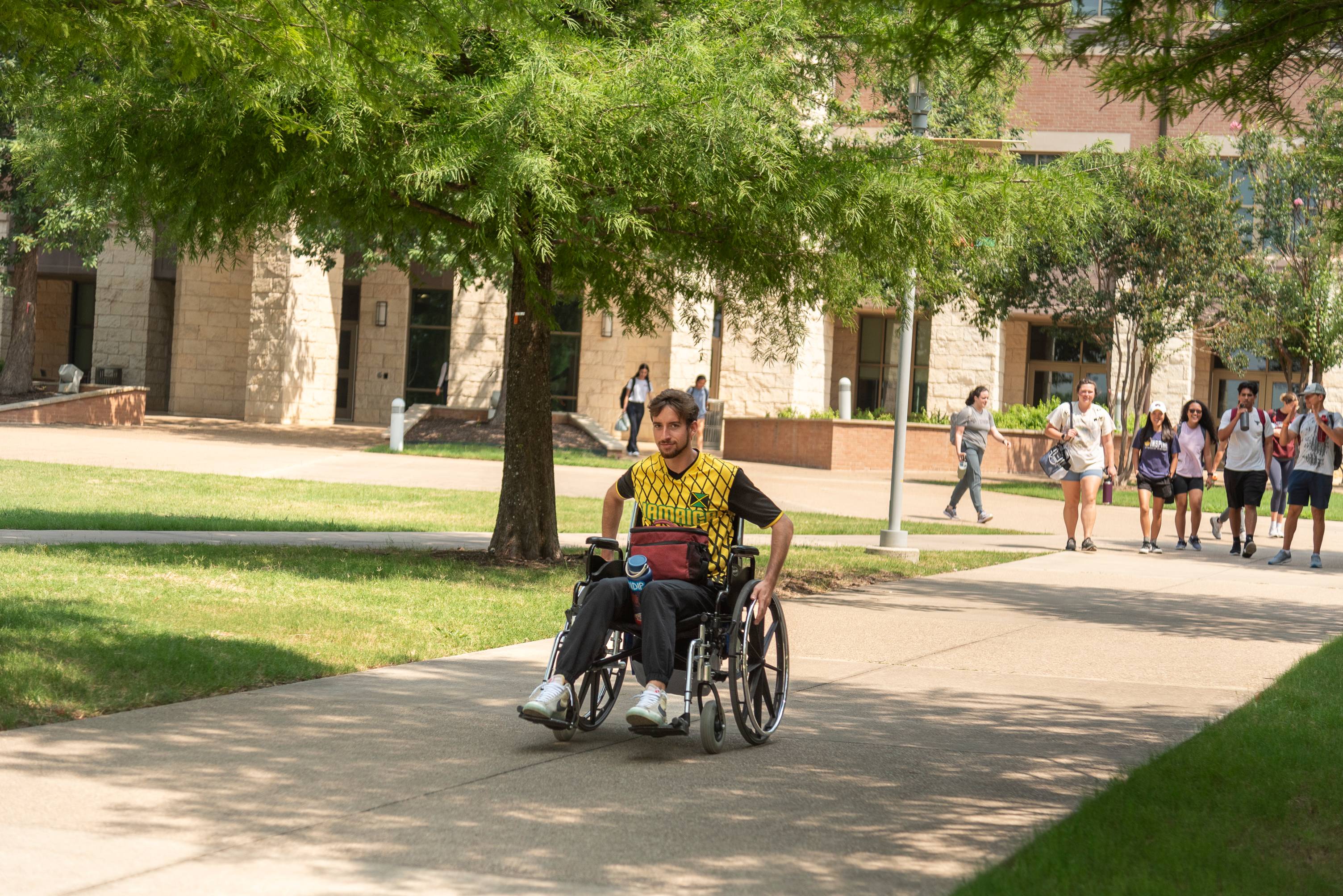 A student using a wheelchair navigates through campus.