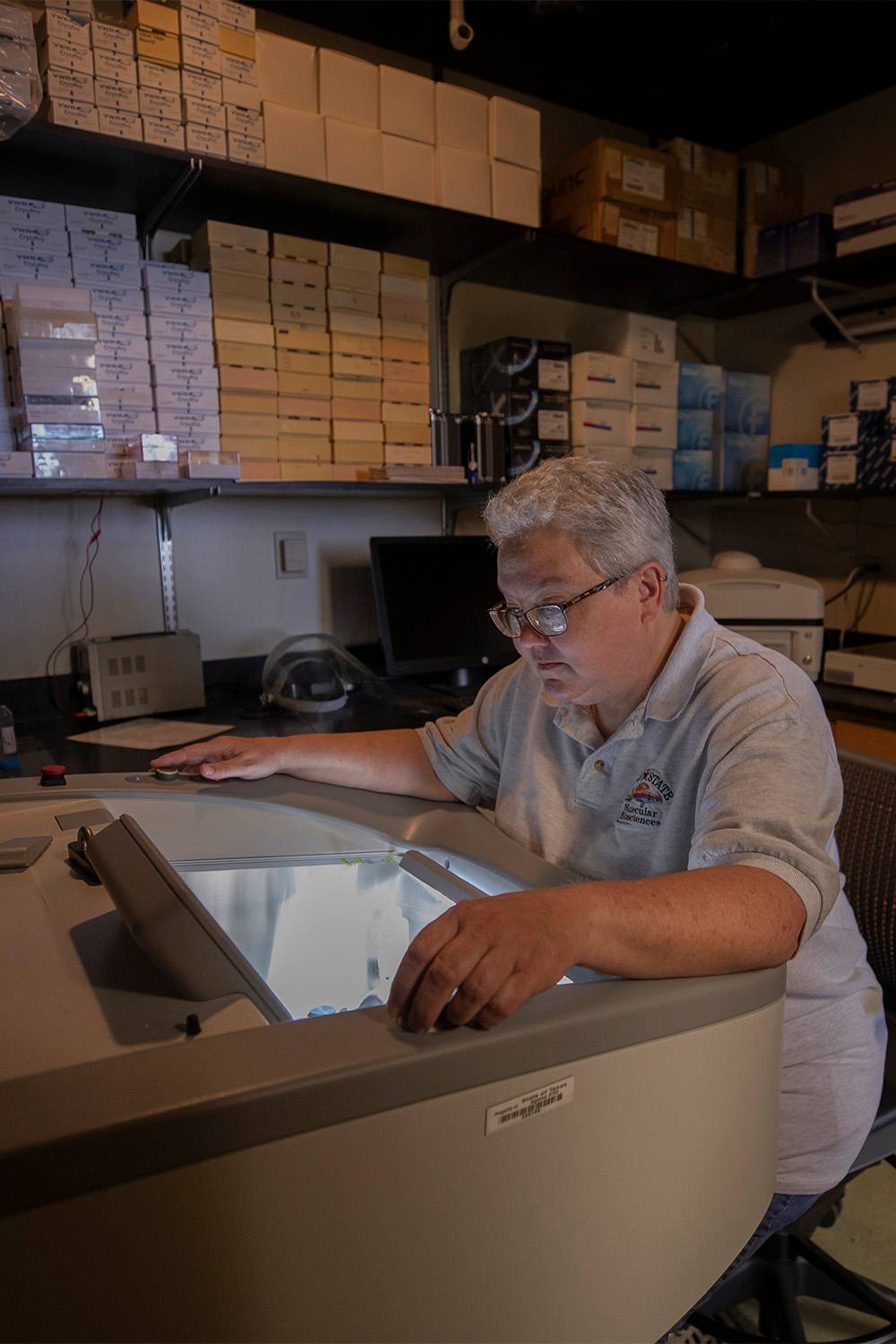 A chemistry researcher at Texas State's STAR Park pauses in his work to discuss something with a person off-camera. 