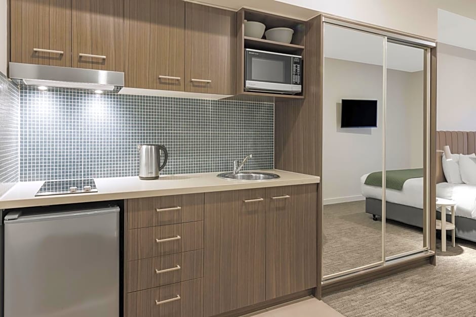 view of kitchen with sink, microwave, and minifridge inside Quest Bundoora room.
