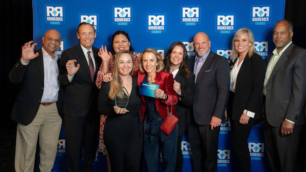 A group of TXST staff members and Round Rock Chamber of Commerce members pose for a photo.