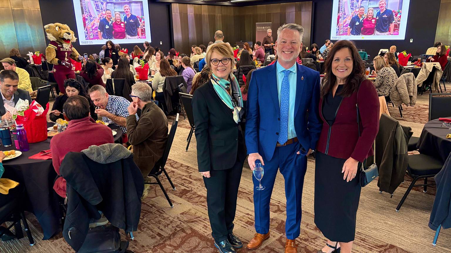 First Lady Beth Damphousse (right) poses for a photo with TXST College of Education staff members at the celebration.