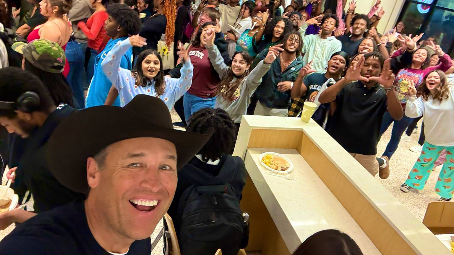 President Kelly Damphouse (left) poses for a picture with TXST students at Late Night Breakfast.