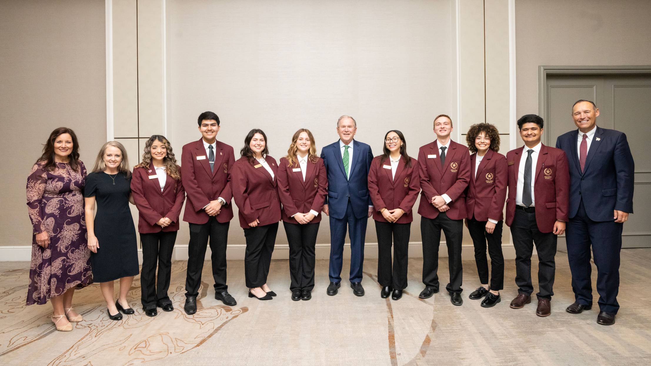 First Lady Beth Damphousse (left) poses for a photo with George W. Bush (middle) and President Kelly Damphousse (right) along with TXST Mariachi students.