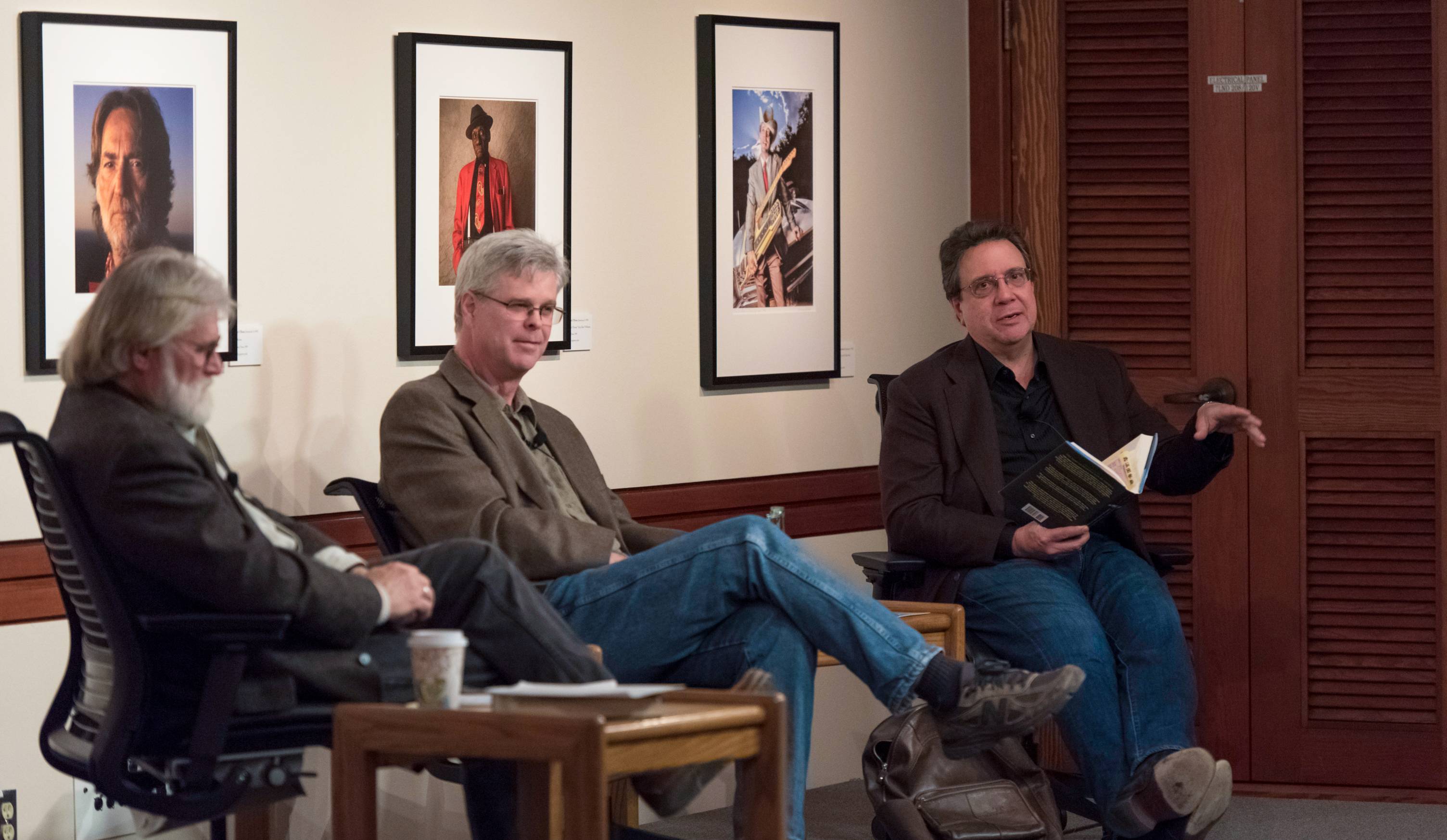 three people sitting at a book reading