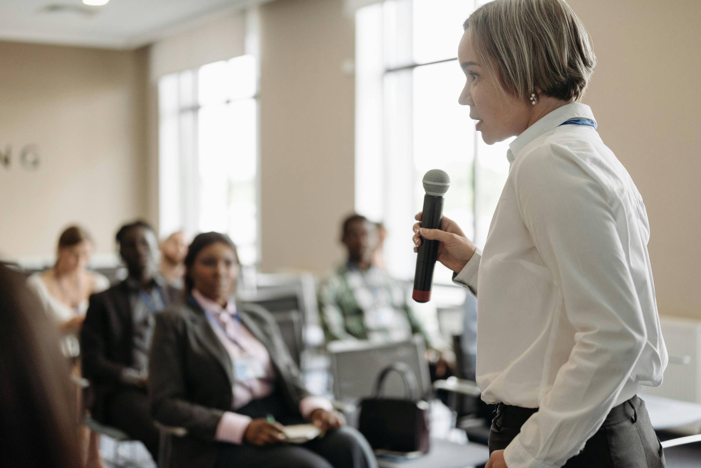 A woman presenting, holding a microphone