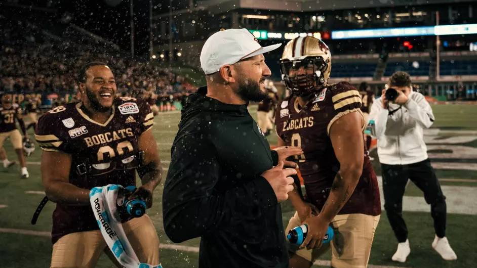 Coach Kinne and football players celebrating bowl game win