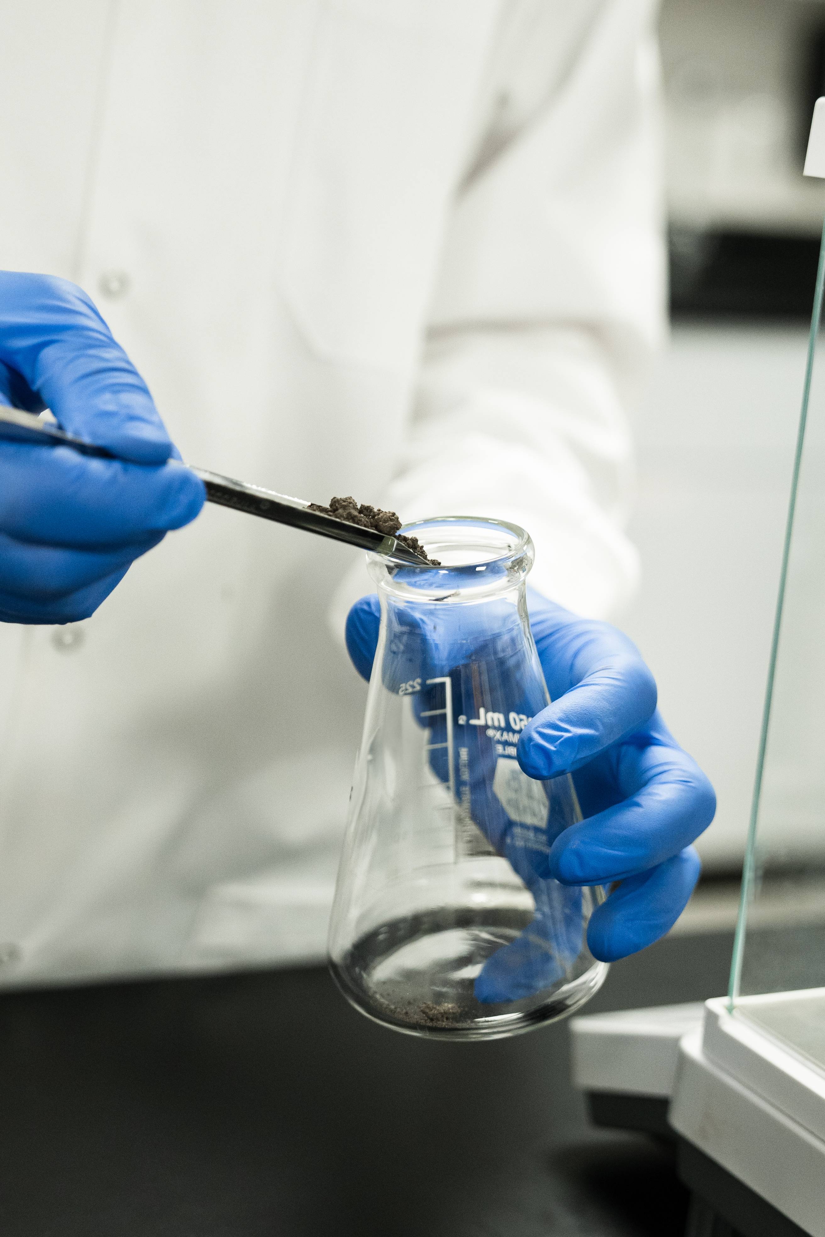 Soil being placed in a beaker