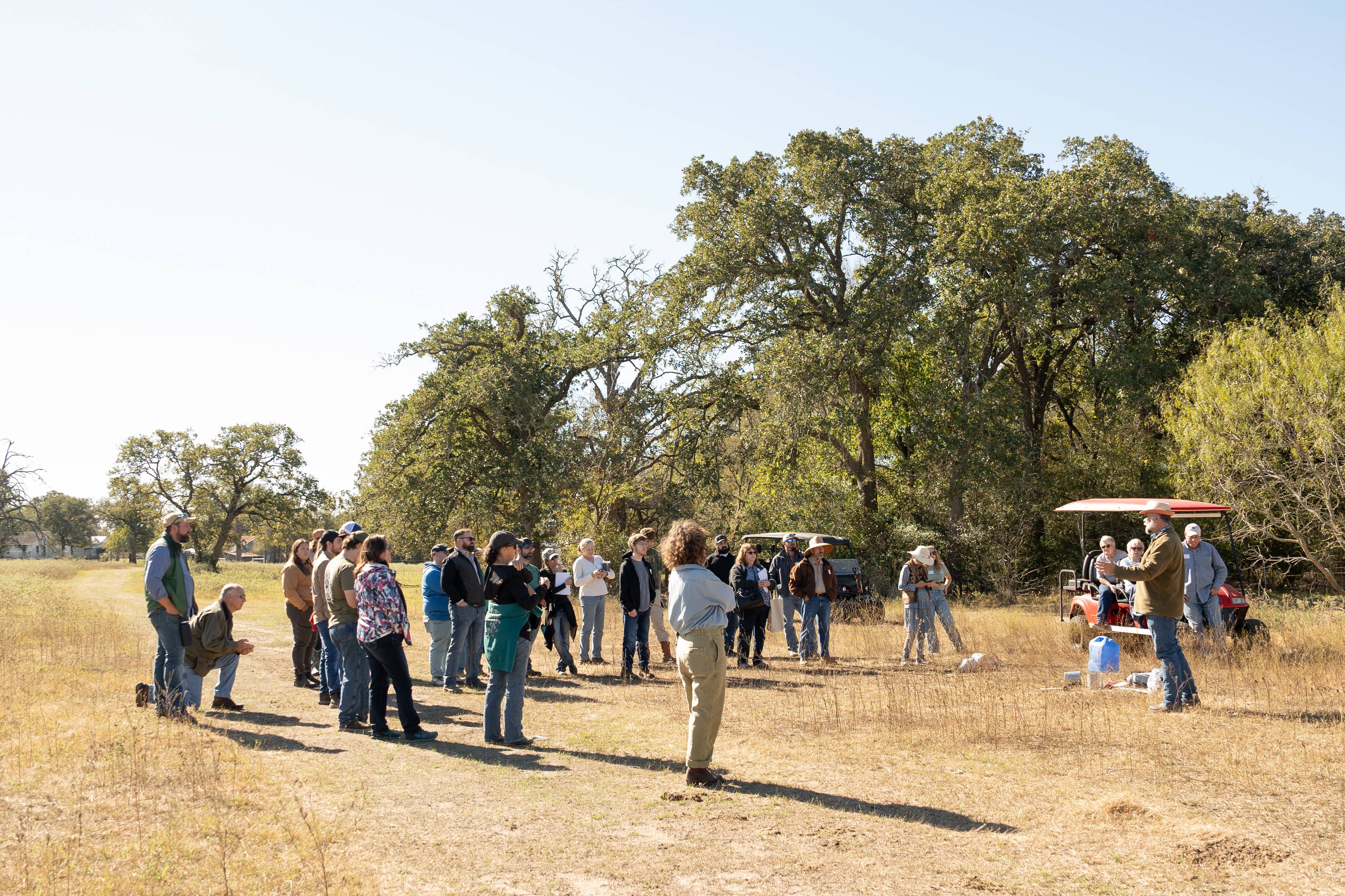 Group of people standing in a semi-circle outside