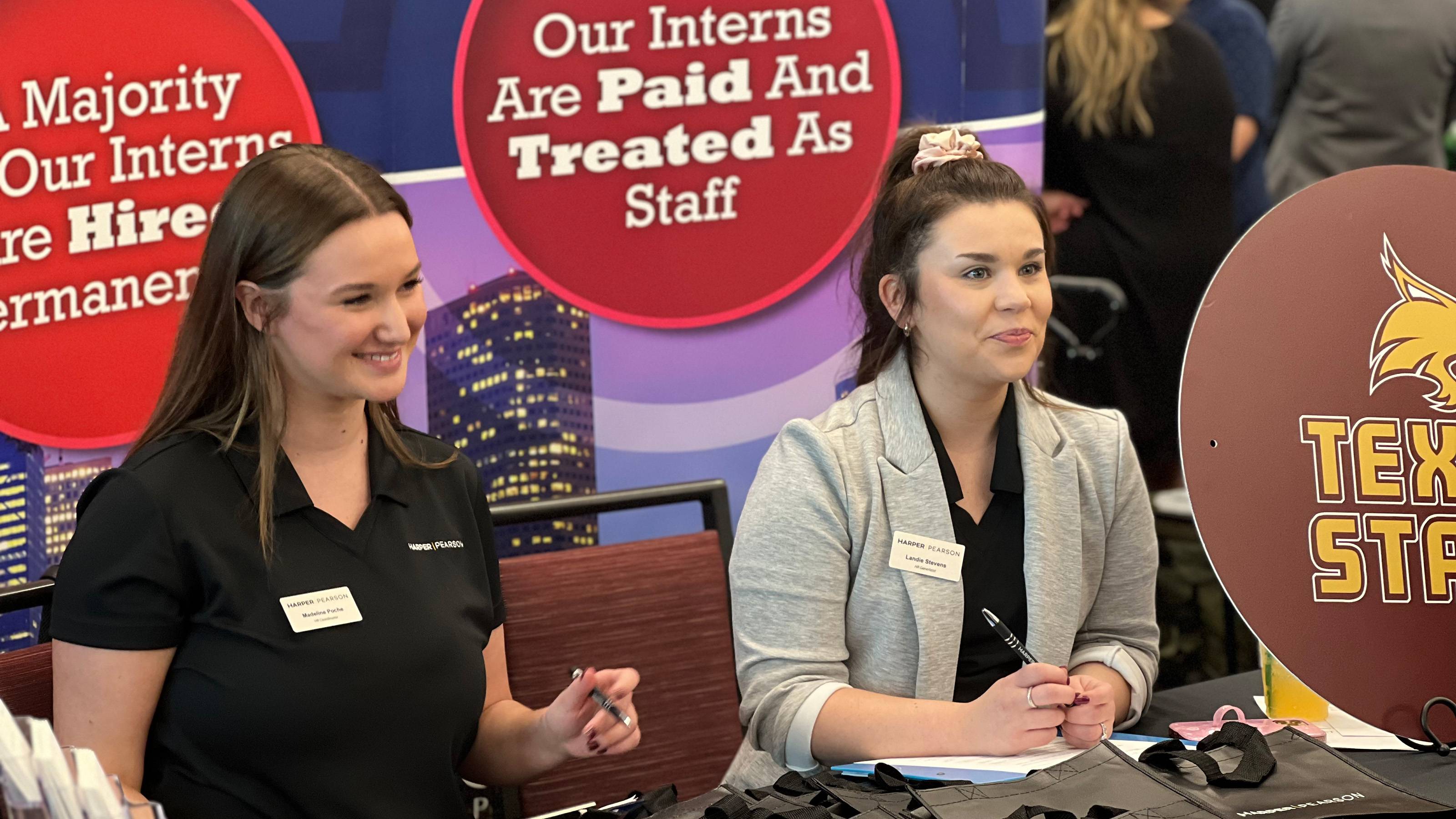 Two women seated at table meeting with prospective employees