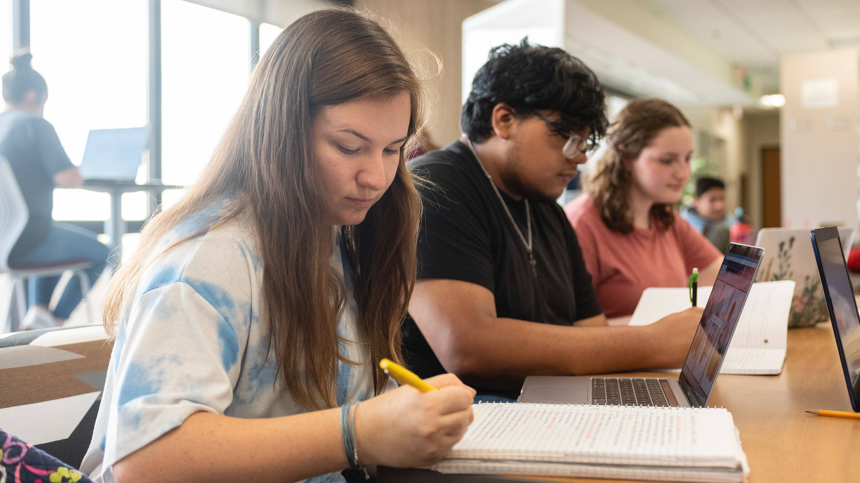 A group of students work at a table together.