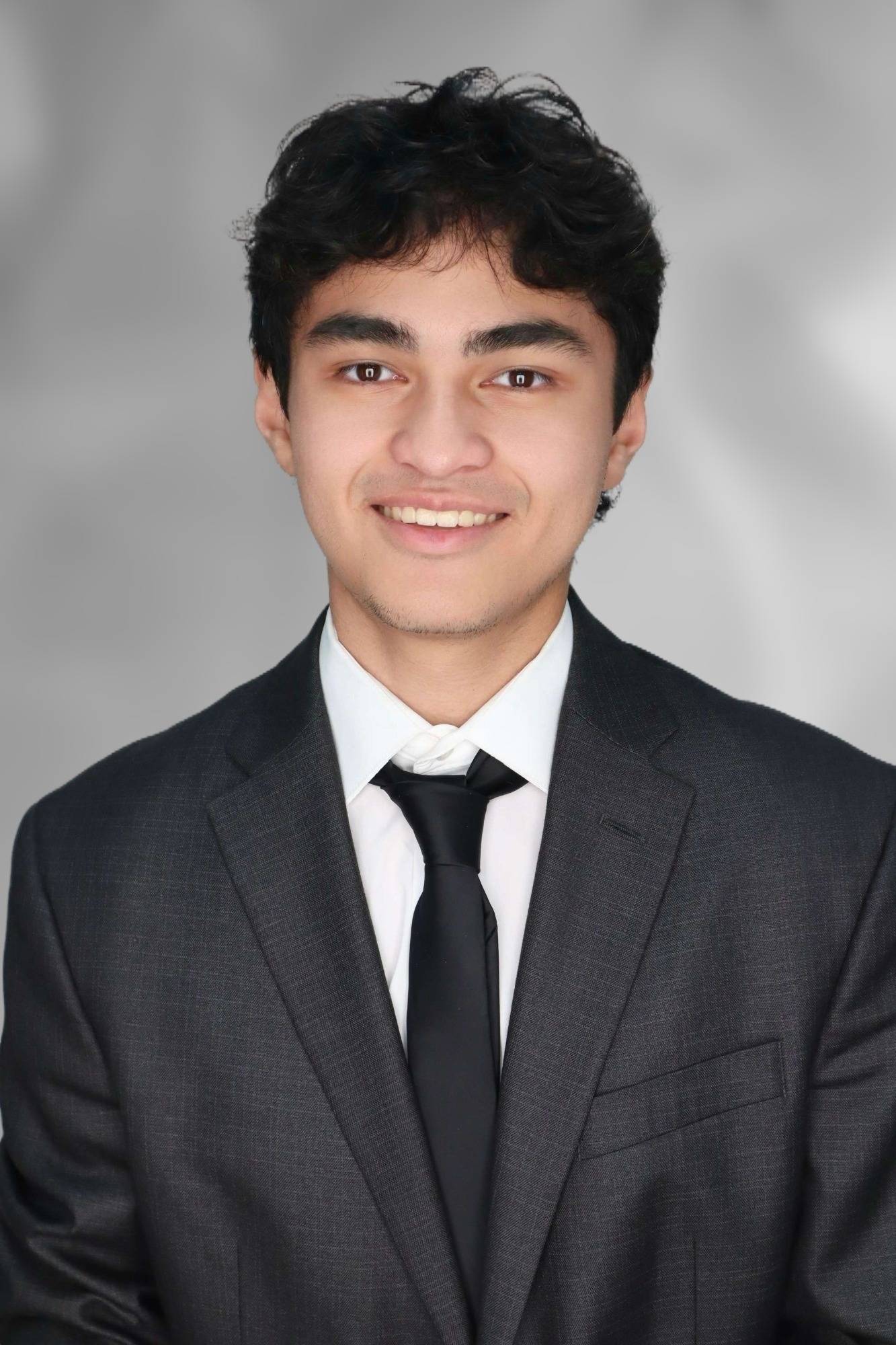 Aaron Soltani headshot - boy in suit smiling 