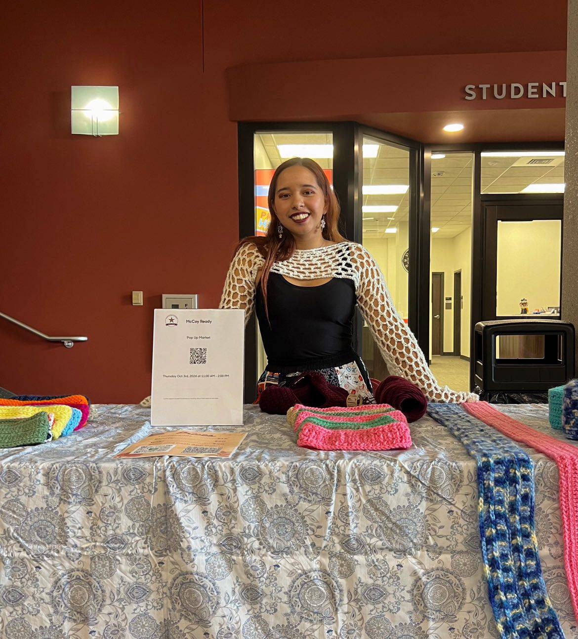 Faith with her crochet crafts smiling at pop-up market 