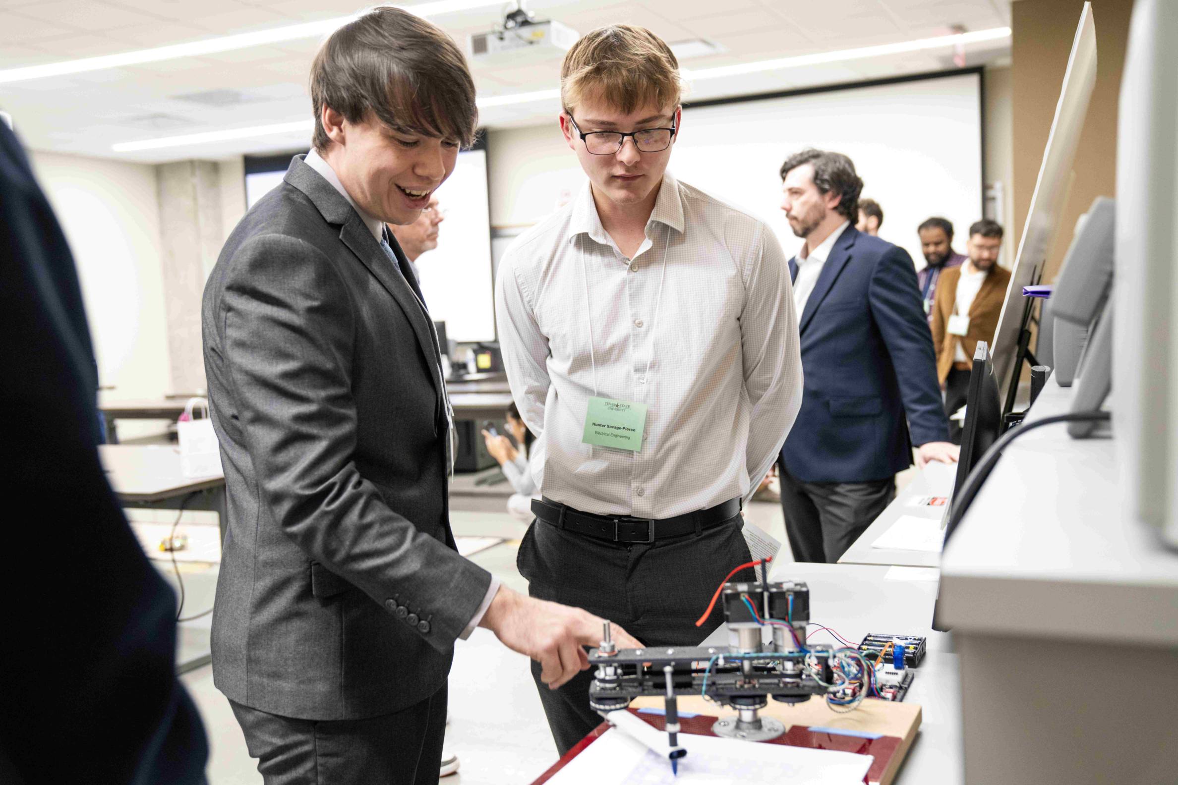 One student shows off his senior design project to another