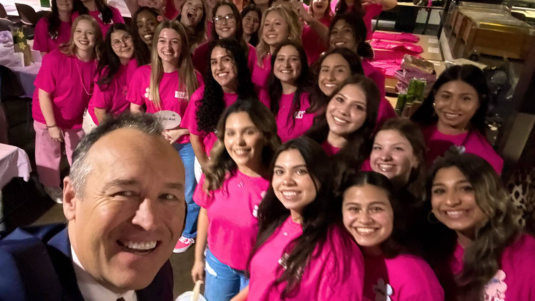 President Kelly Damphousse (left) takes a selfie with a group of Bobcat Belles students.