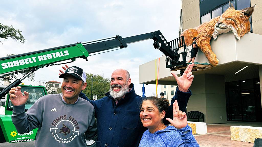 President Damphousse (left) poses for a photo with artist Matthew Mazzotta and Cynthia Hernandez in front of the new Bobcat sculpture.