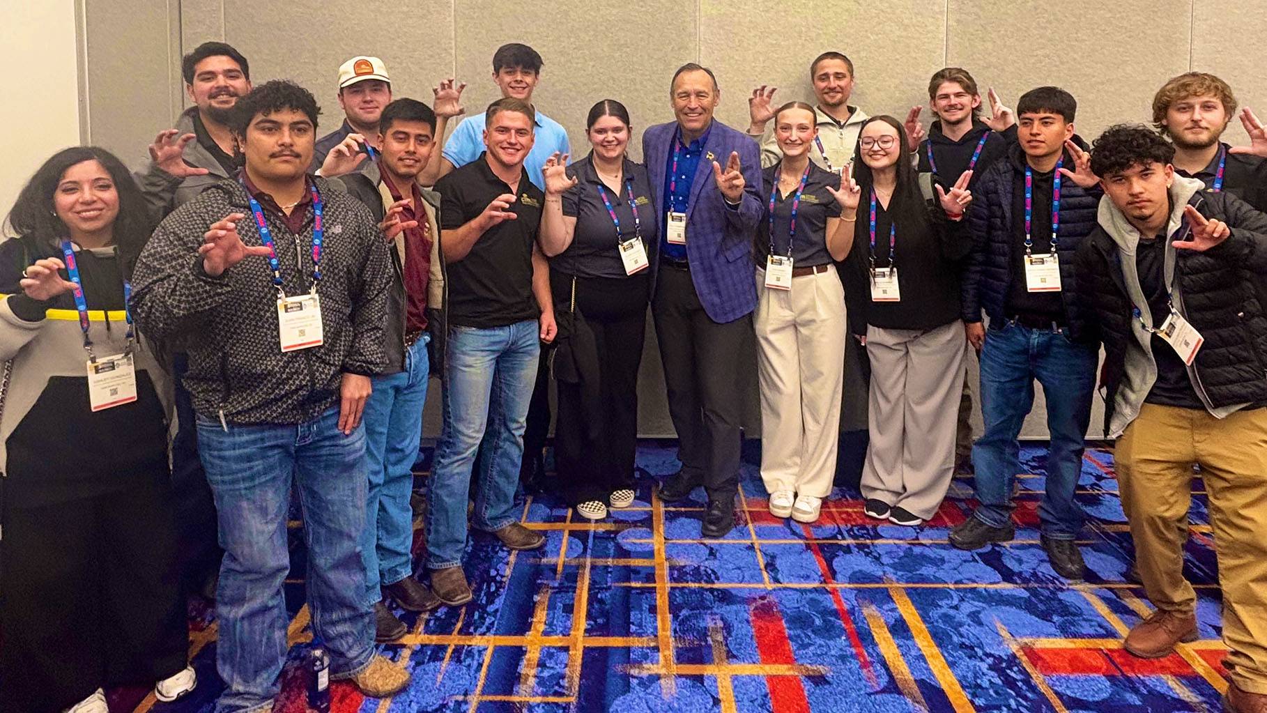 President Kelly Damphousse poses for a photo with a large group of CIM students.