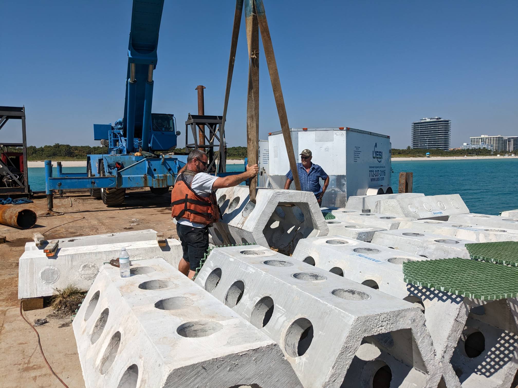 Researchers prepare the concrete seahives to be lowered into the ocean via crane off the coast of Miami.