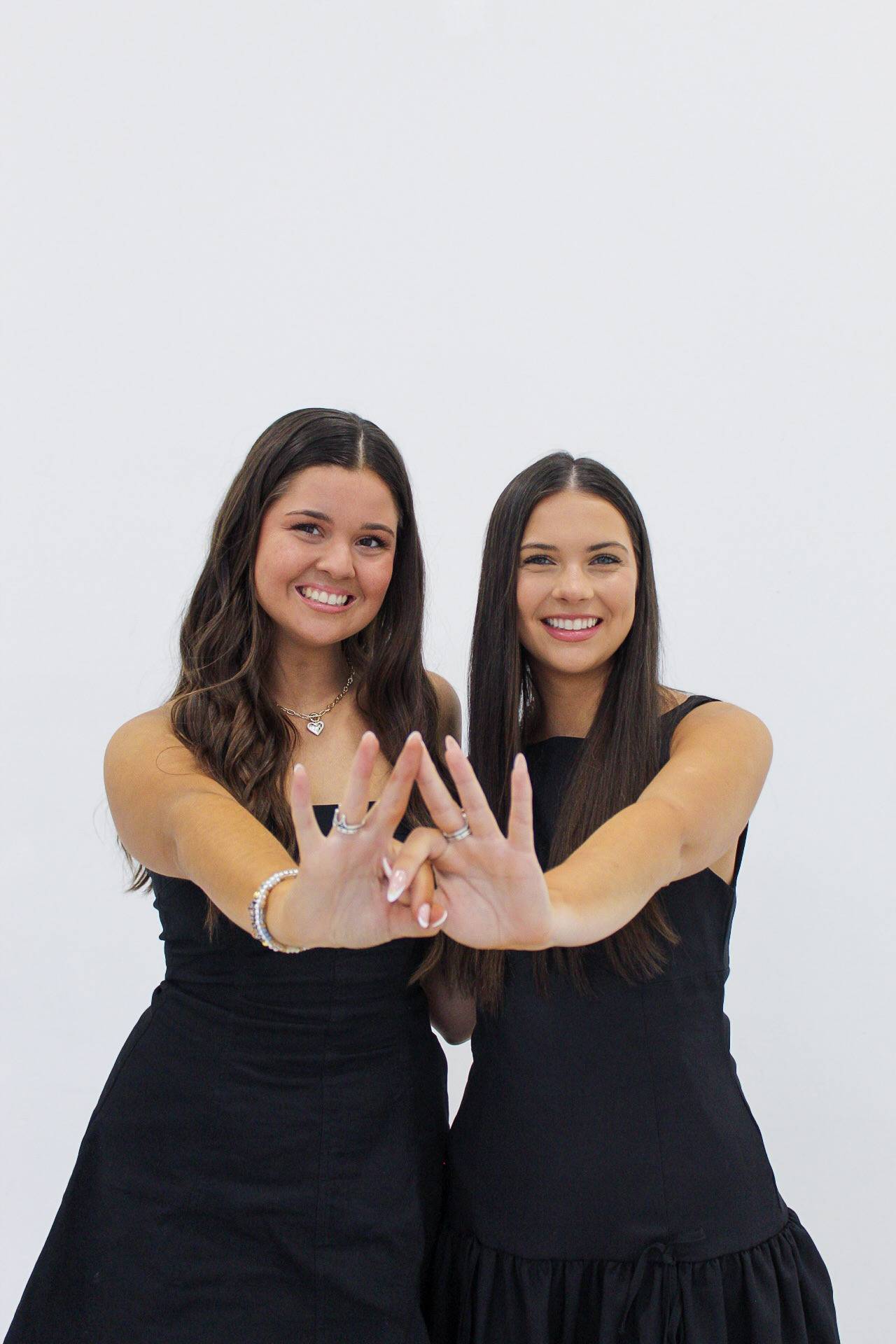 Two women posing with ZTA hand sign