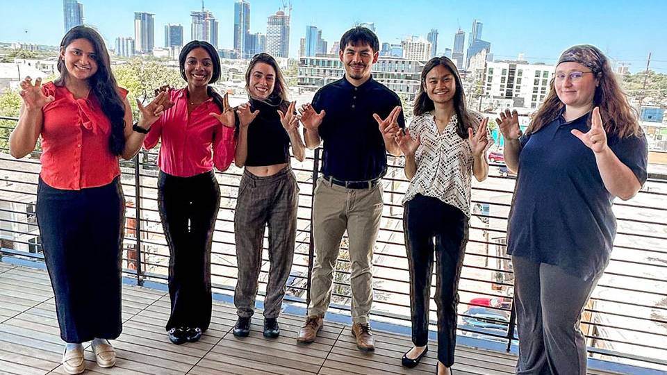 A group of TXST students pose for a picture on a pier in Austin.