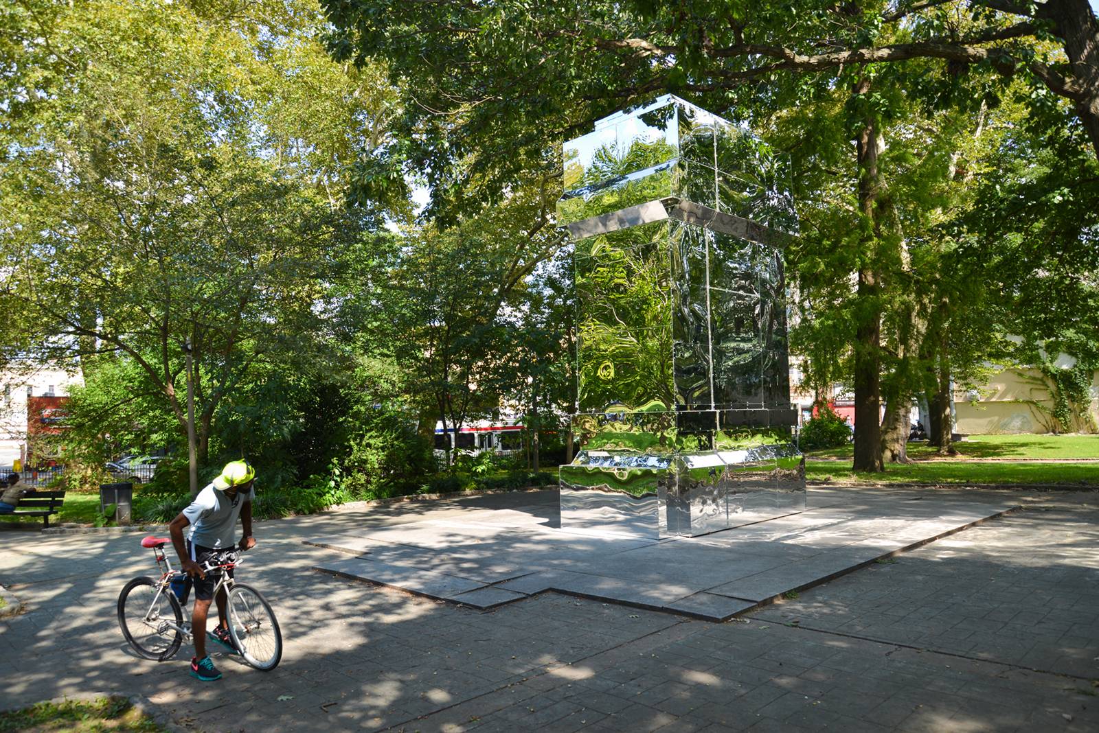 A large pillar of reflective material in a public parkl