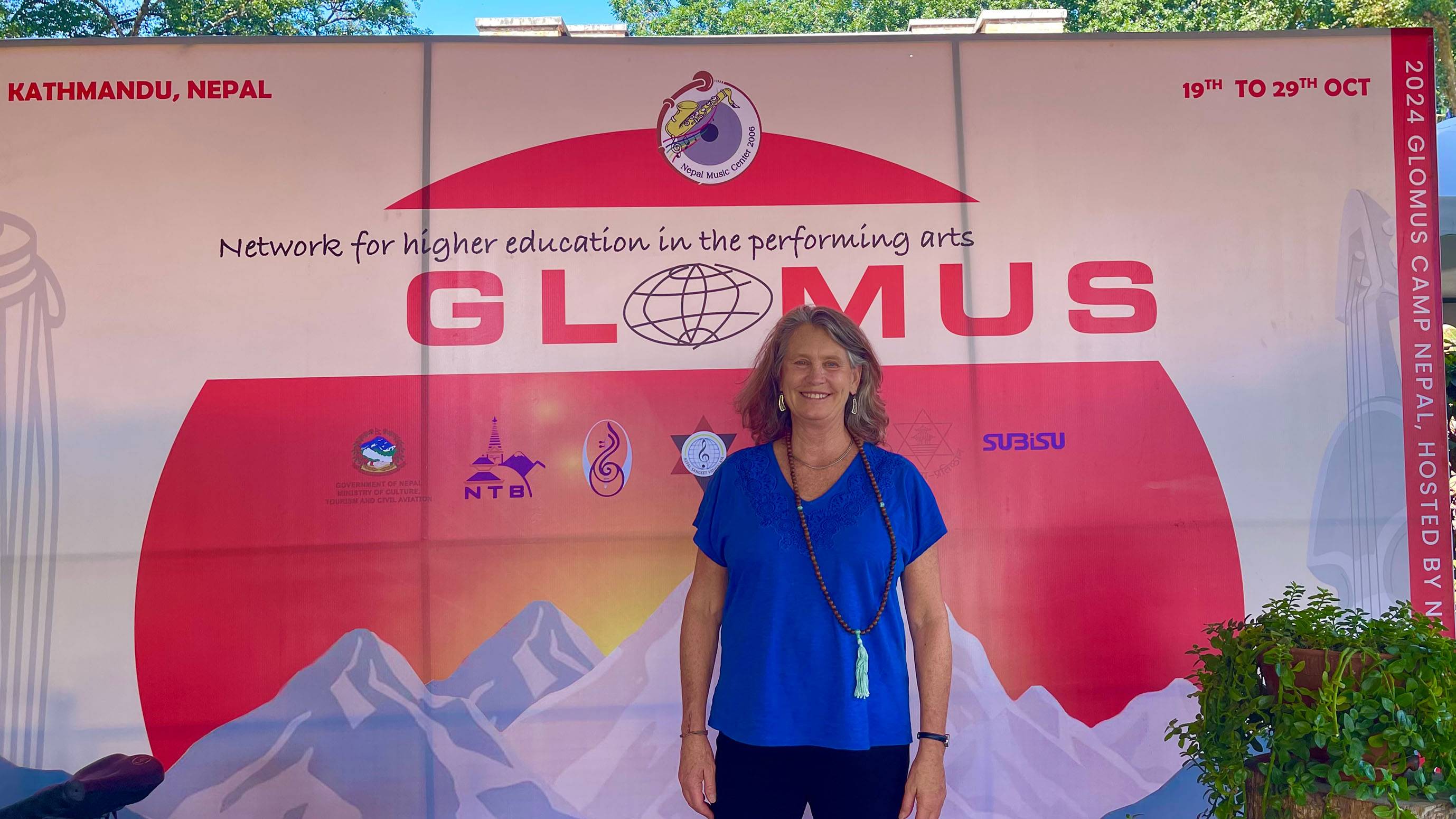 Wissler poses for a photo in front of the Glomus Camp banner.