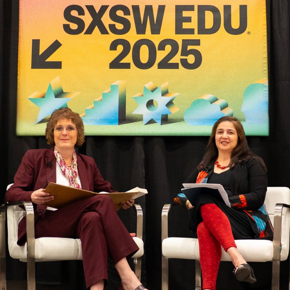 Photo of Andrea Golato and Rajiki Bhandari in front of the SXSW banner