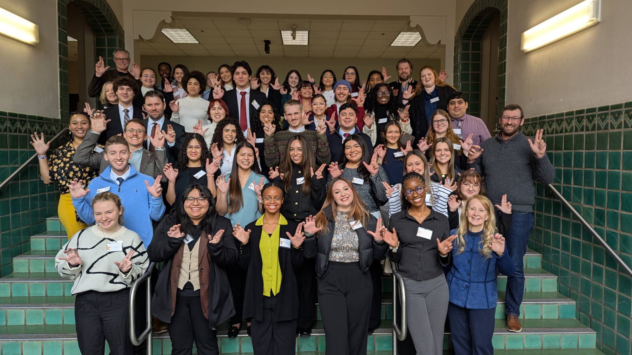 Group picture of the 2025 networking event, participants hold the "States up" hand sign