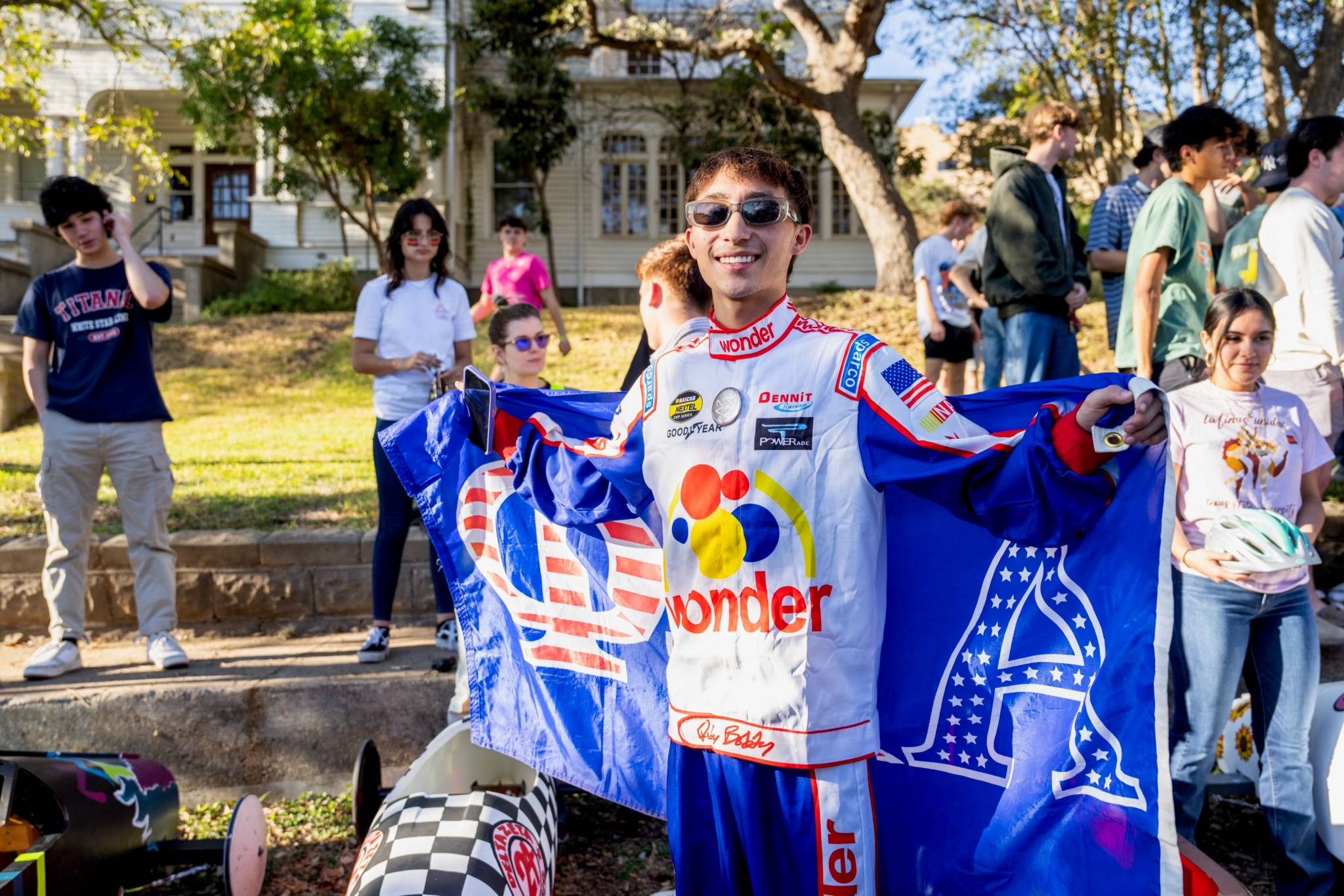 Alpha Sig member posing with flag at soap box derby 