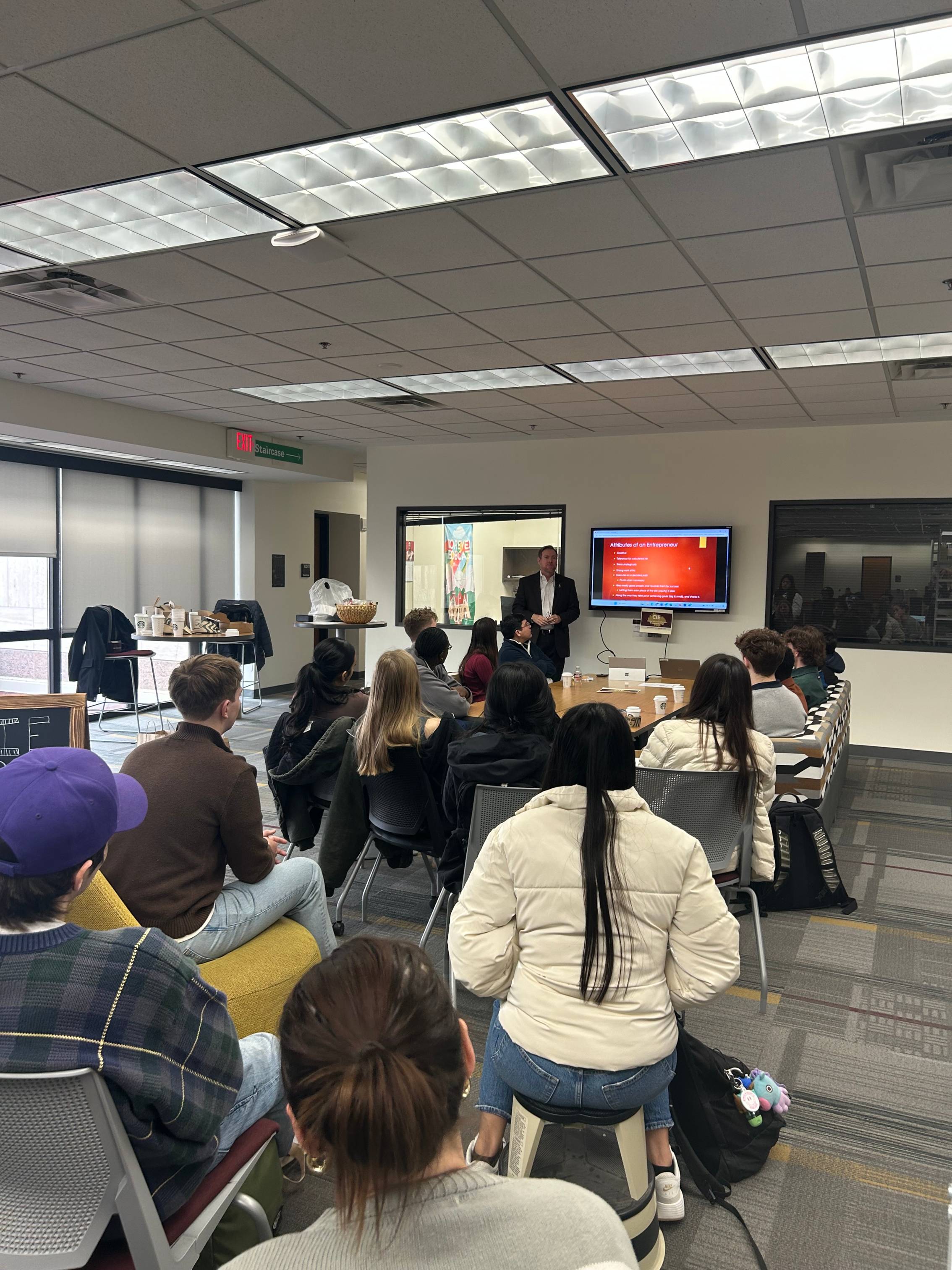 Students listening to CIE speaker series gust Jeff Willis speak around the CIE gathering space 