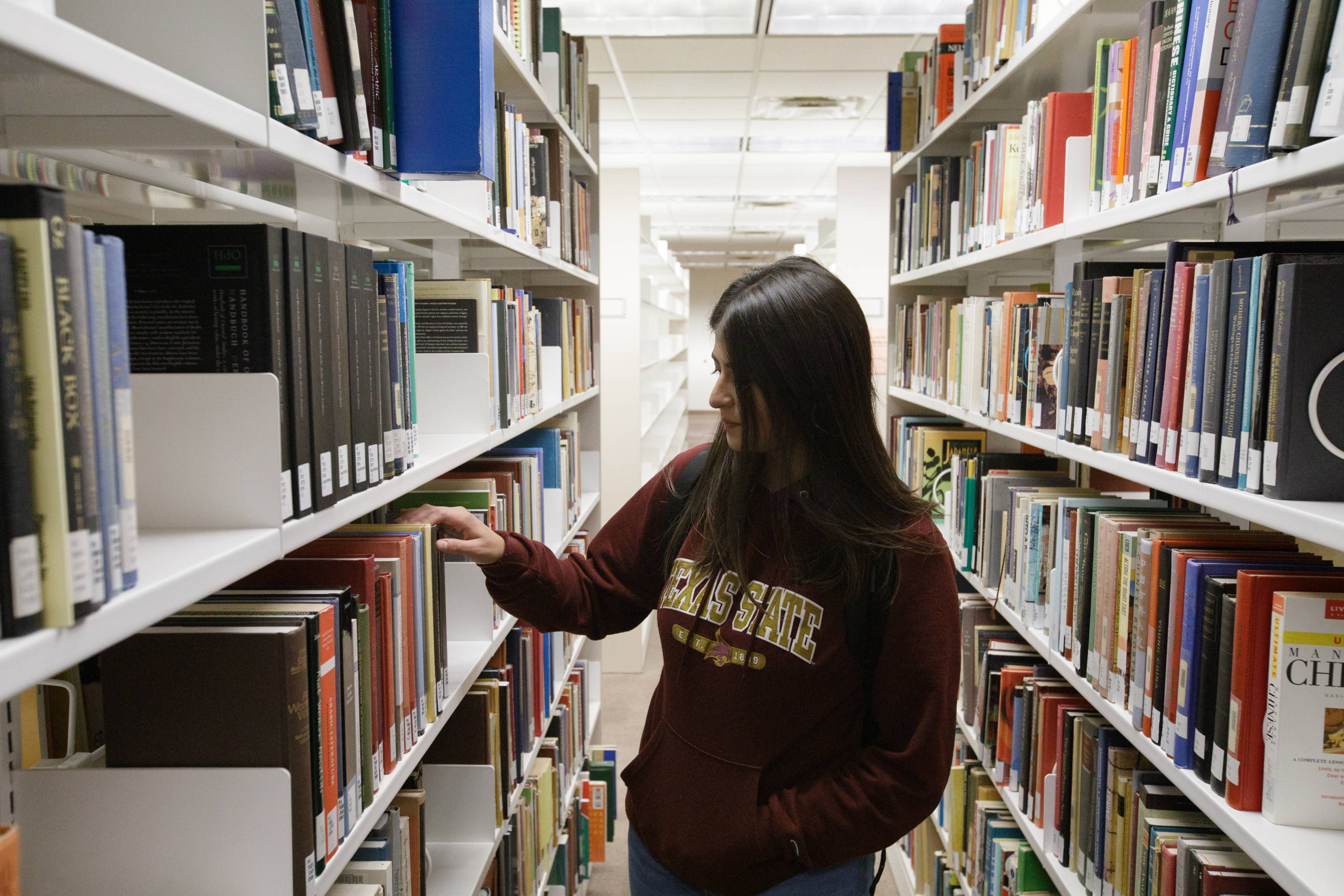 student looking for a book in the book racks